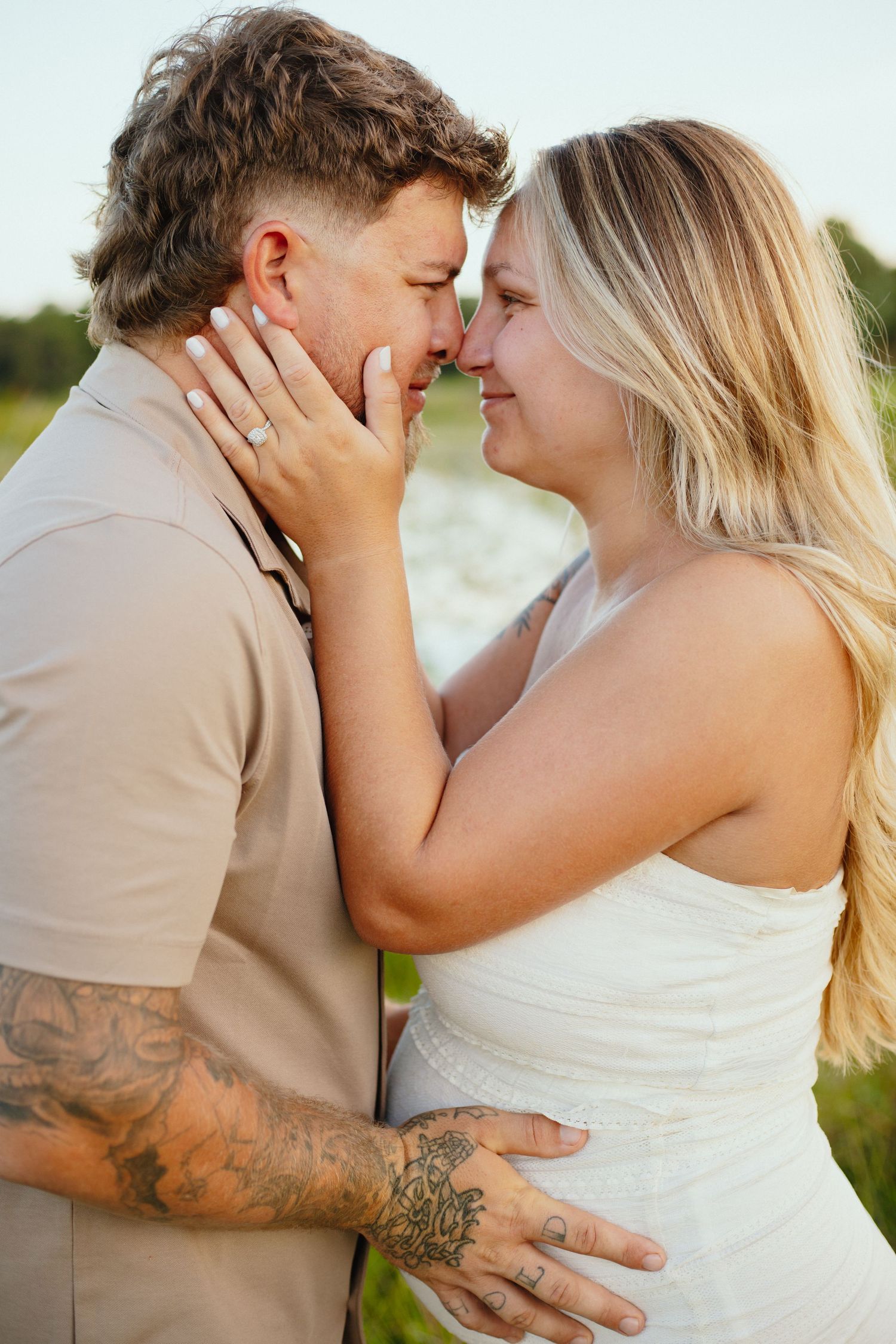 Romantic maternity photos captured outdoors with couple sharing intimate moments.
