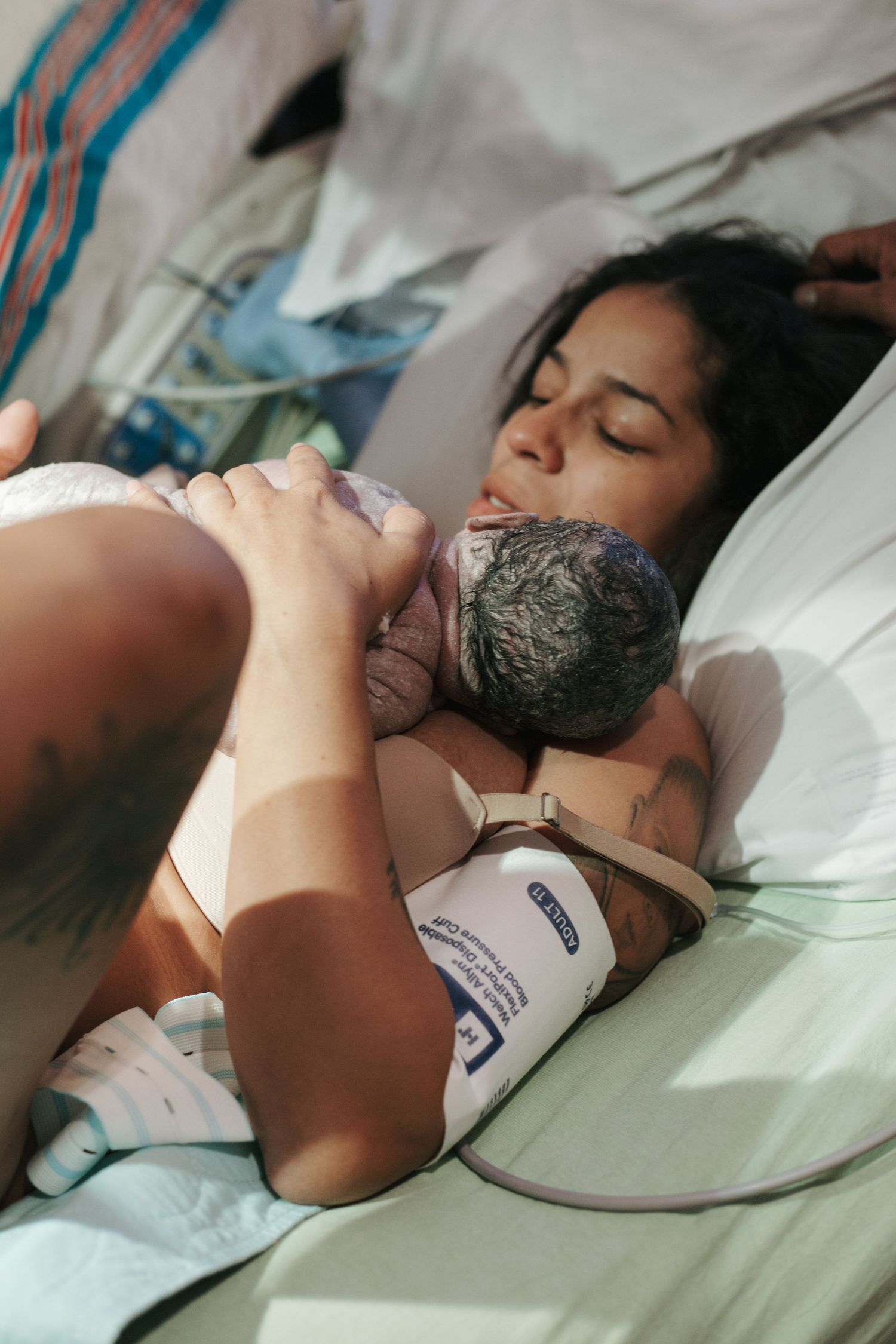 Peaceful moments of bonding between parent and newborn in a hospital setting.