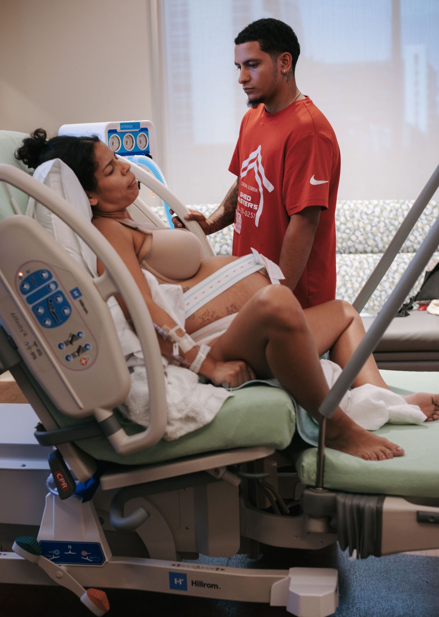 Medical staff attending to patient in a modern hospital delivery room setting.