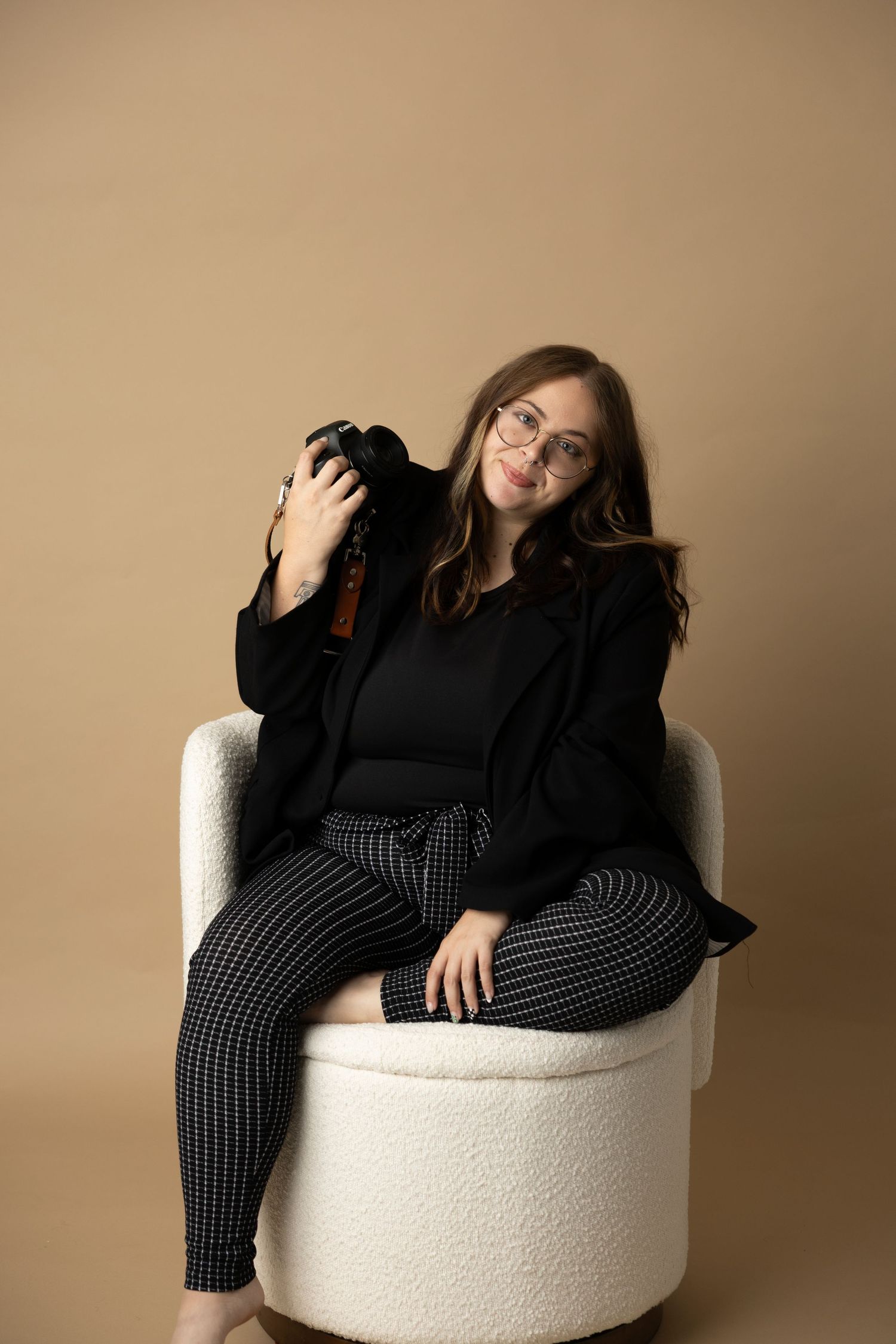 Casual maternity portraits showing relaxed poses in a white round chair against beige backdrop.