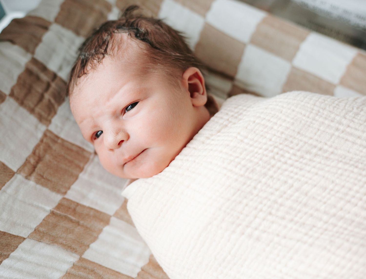 Close-up shots of a sleeping newborn on textured white bedding.