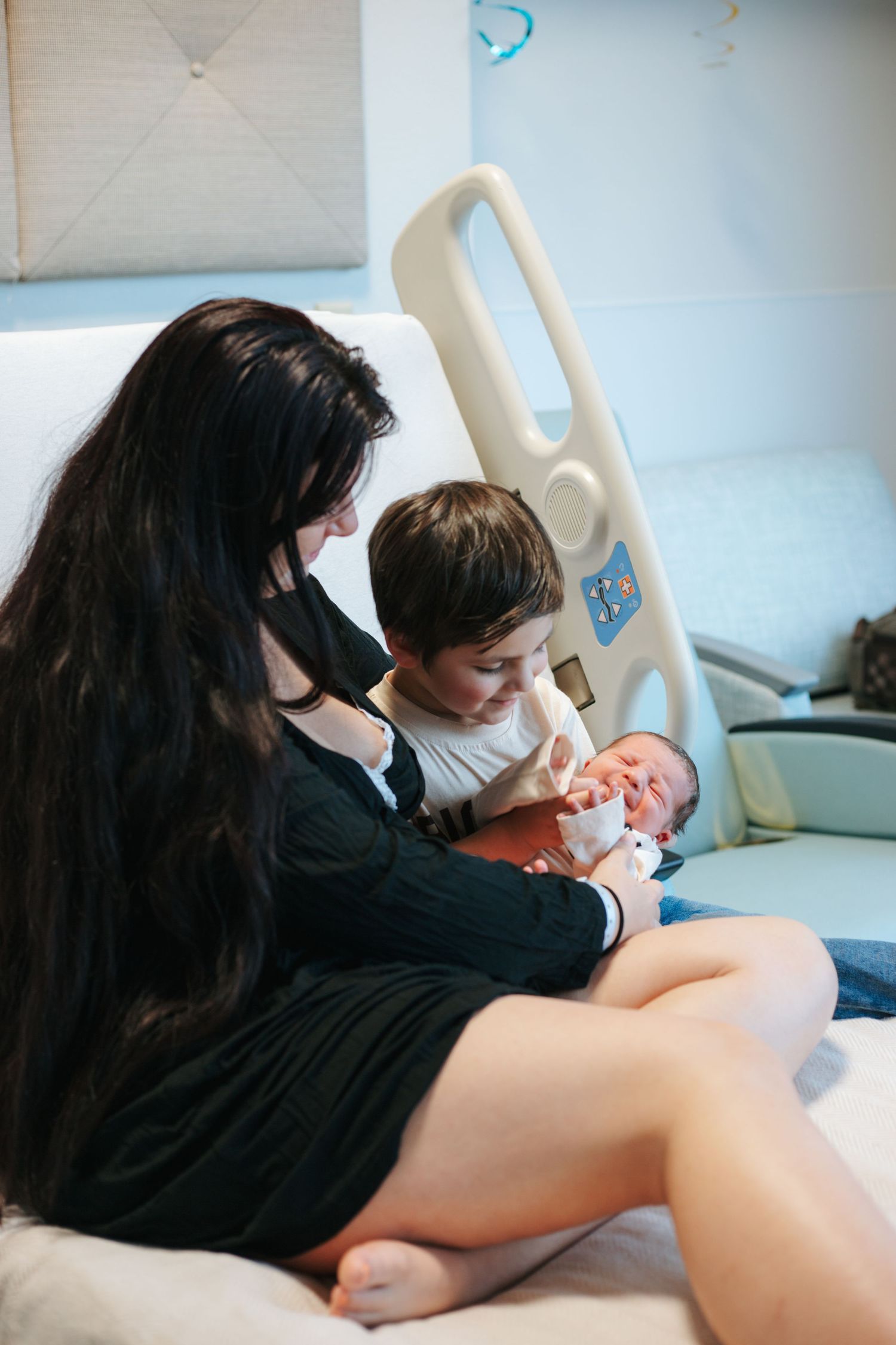 An intimate moment captured in a medical setting with soft blue walls.