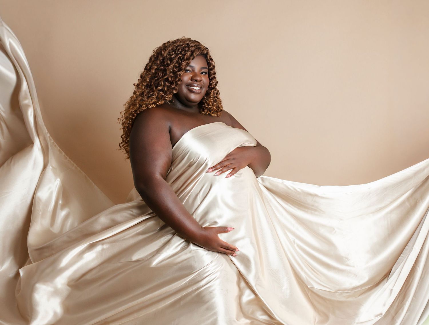 Artistic maternity photos with flowing white fabric creating dramatic movement and texture.