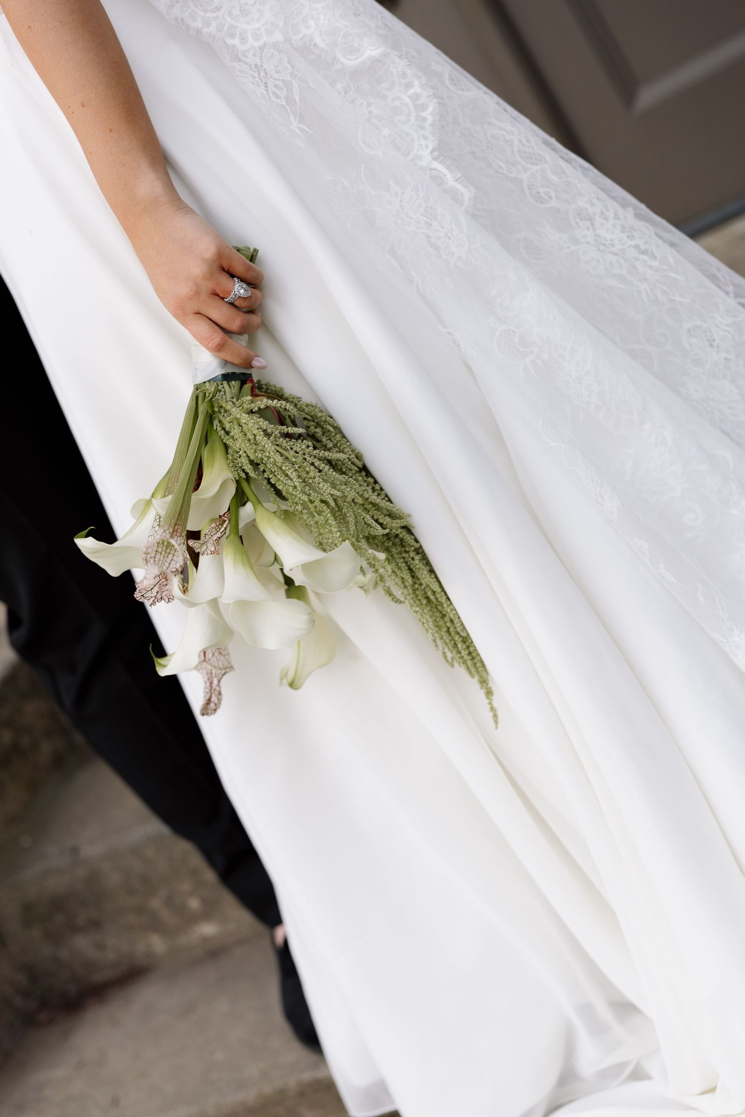 Eolia Mansion at Harkness Memorial Park - Close-up of bride holding elegant white calla lily bouquet with diamond ring visible on her hand.