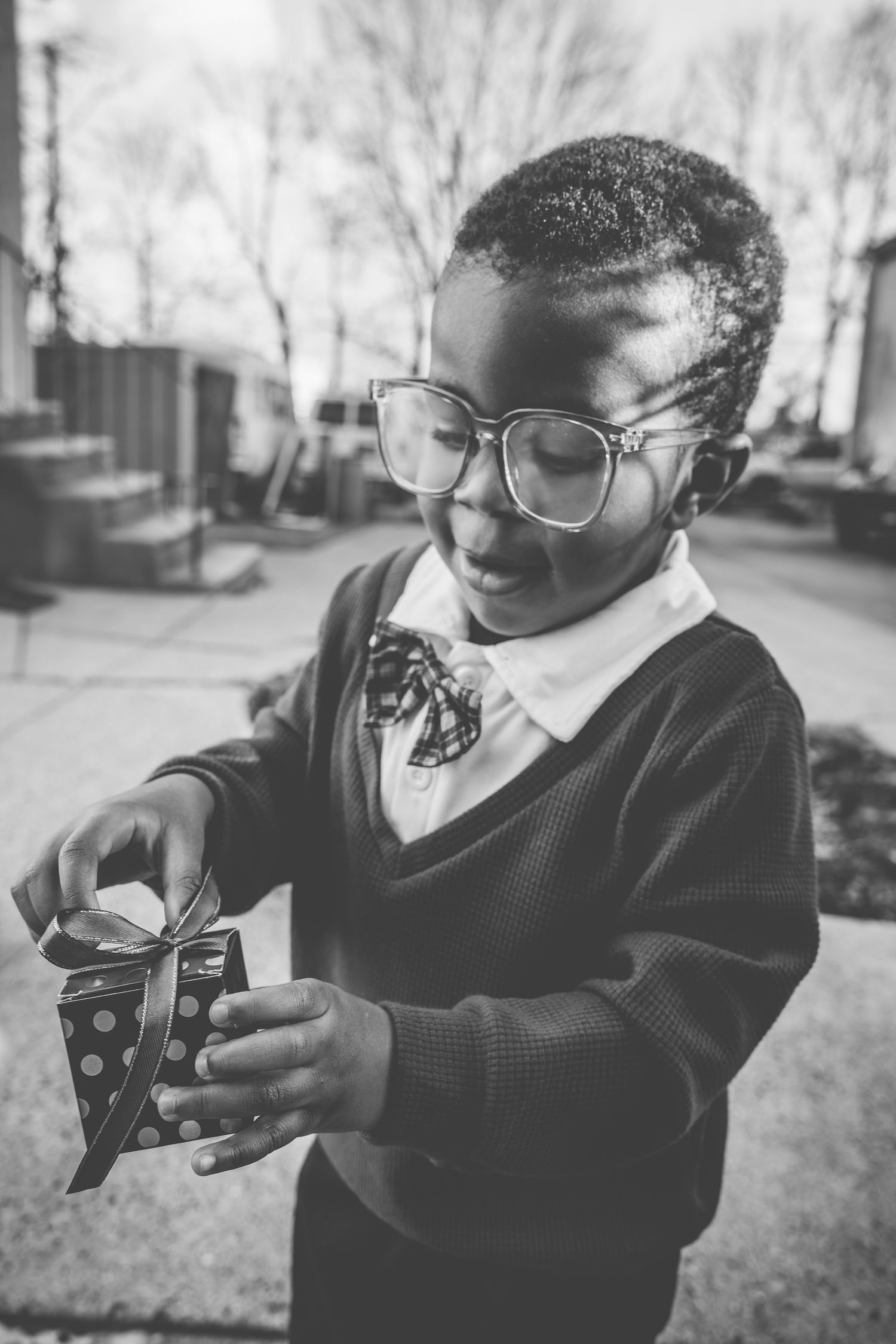 Series of black and white photos showing someone playing with a toy camera outdoors.