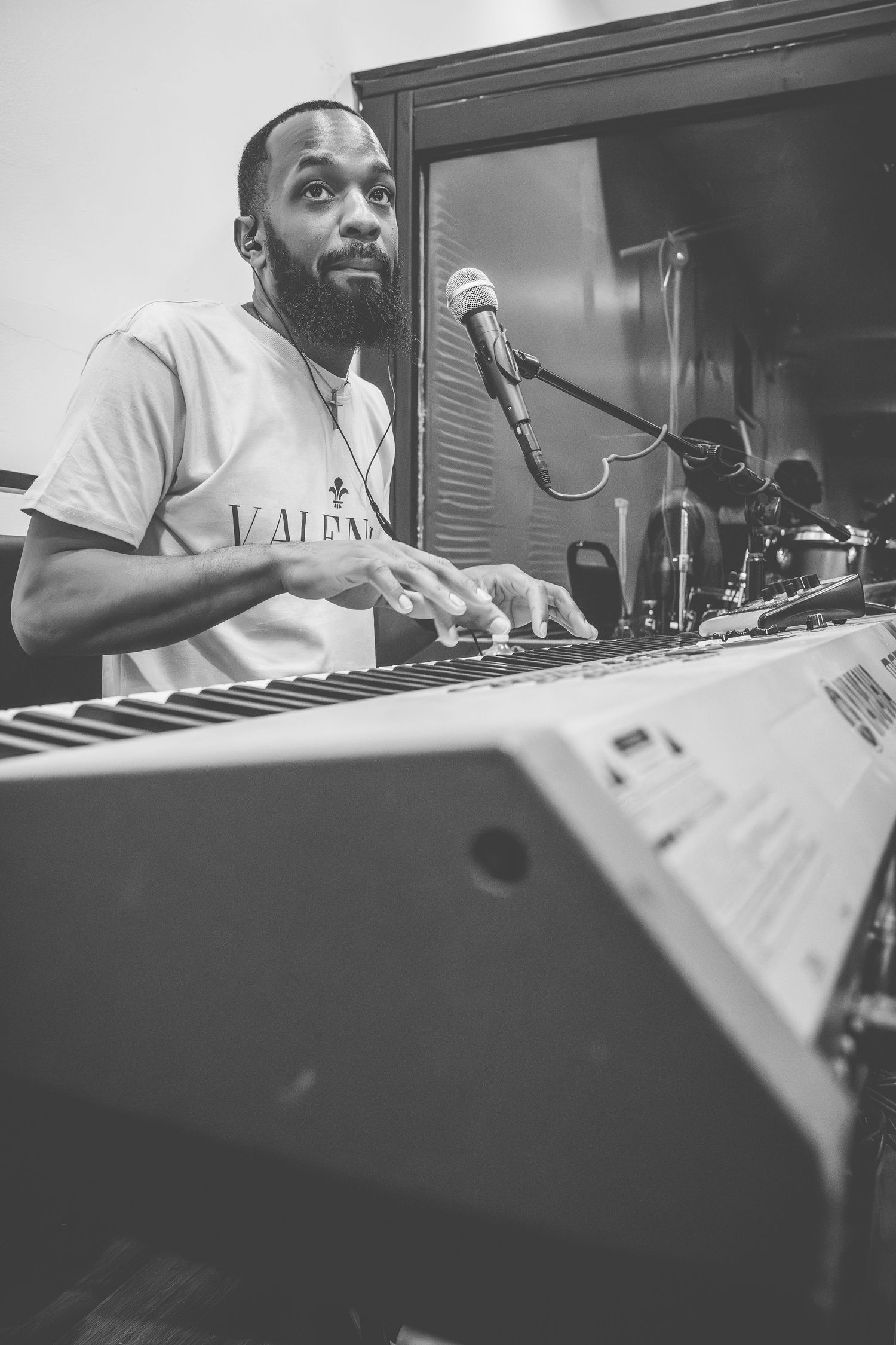 Musician playing keyboard with expressive joy during church service.