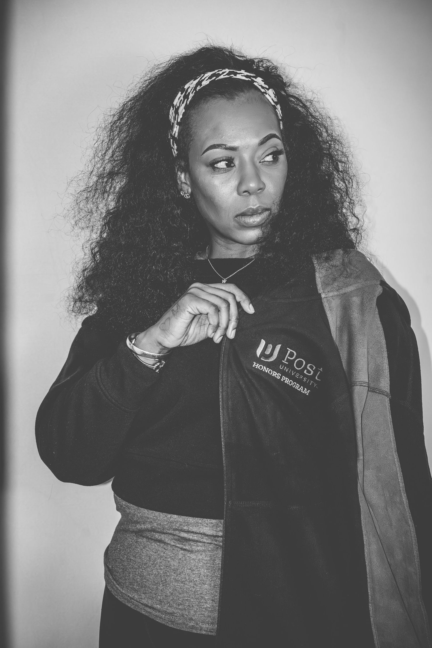 Black and white fashion photoshoot featuring casual streetwear styling with natural curly hair.
