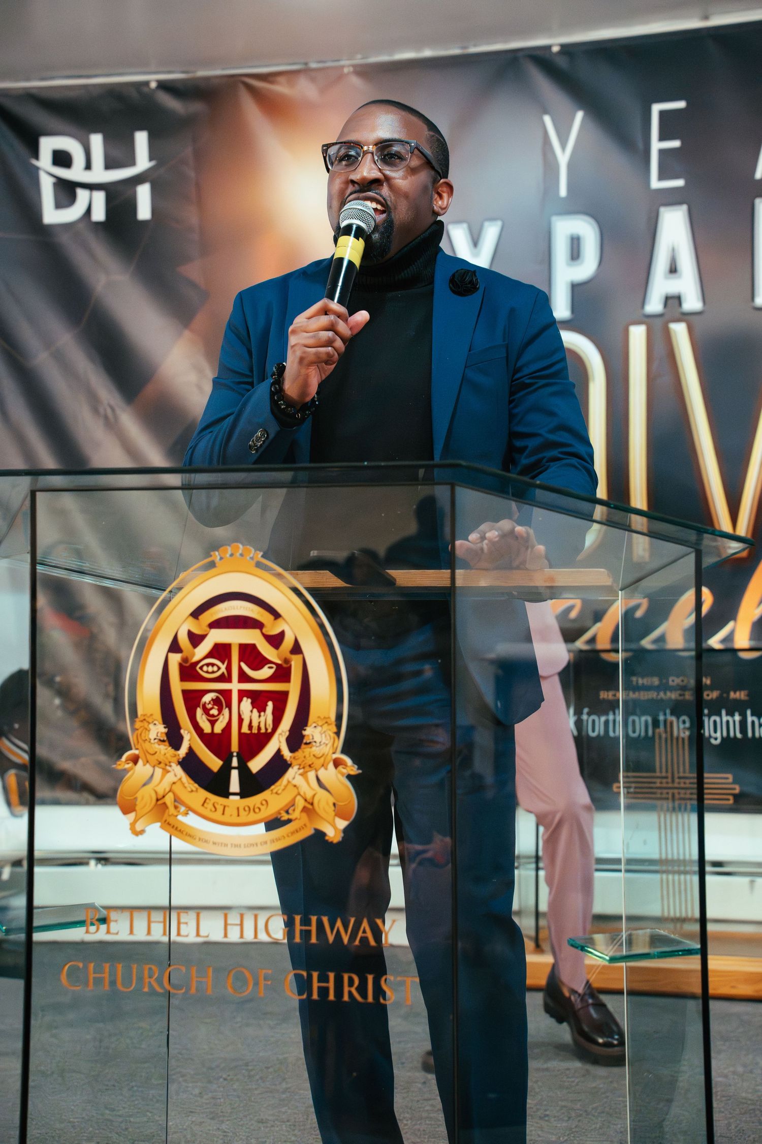 Church podium with golden logo and branding displayed during service.