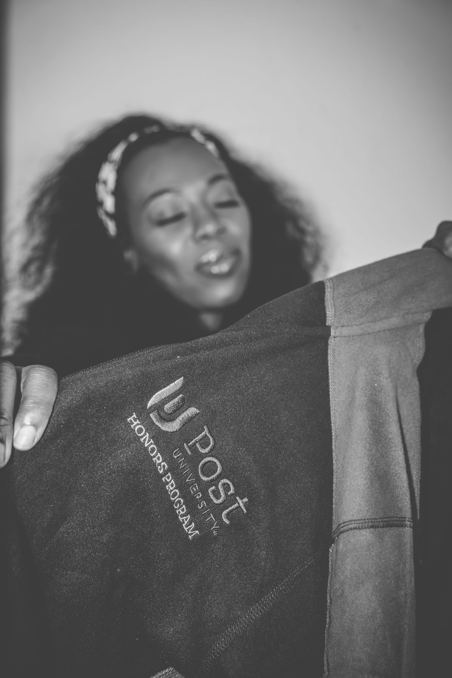Black and white photo showing hands holding Post program materials with blurred background.