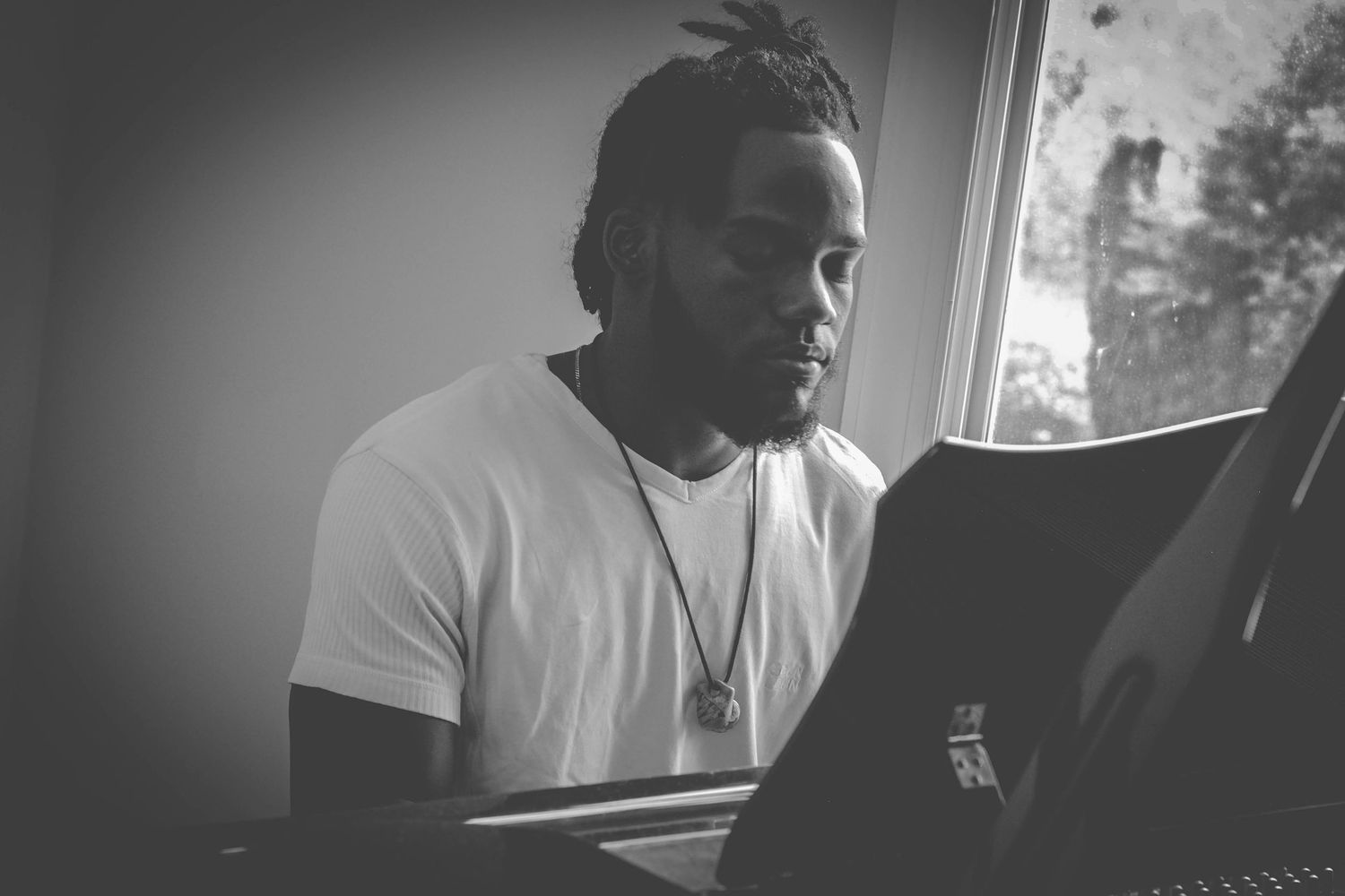 A series of black and white photos showing someone playing piano keys in an intimate studio setting.