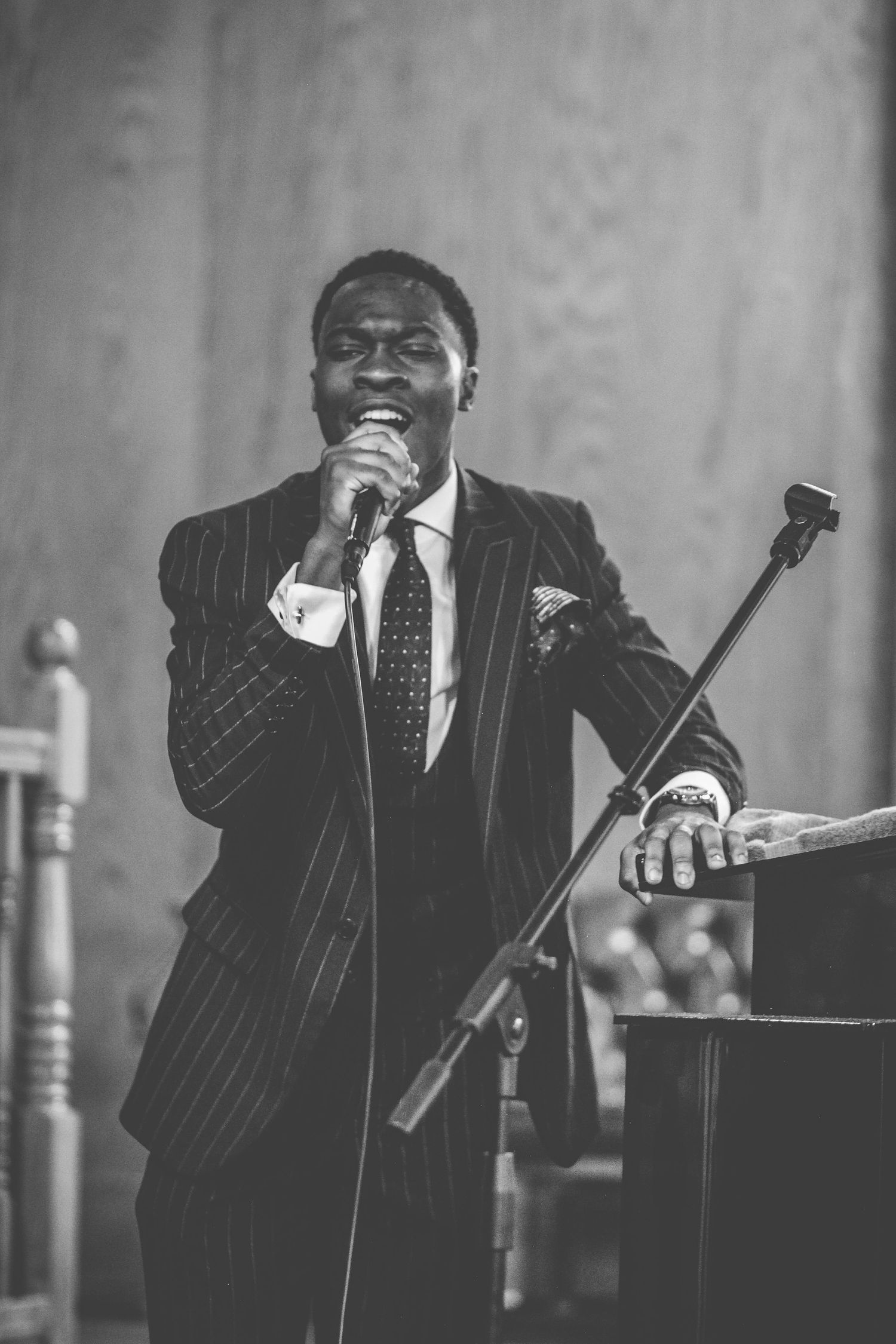 Black and white photo series of a performer in pinstripe suit singing with emotion at a jazz or blues concert.