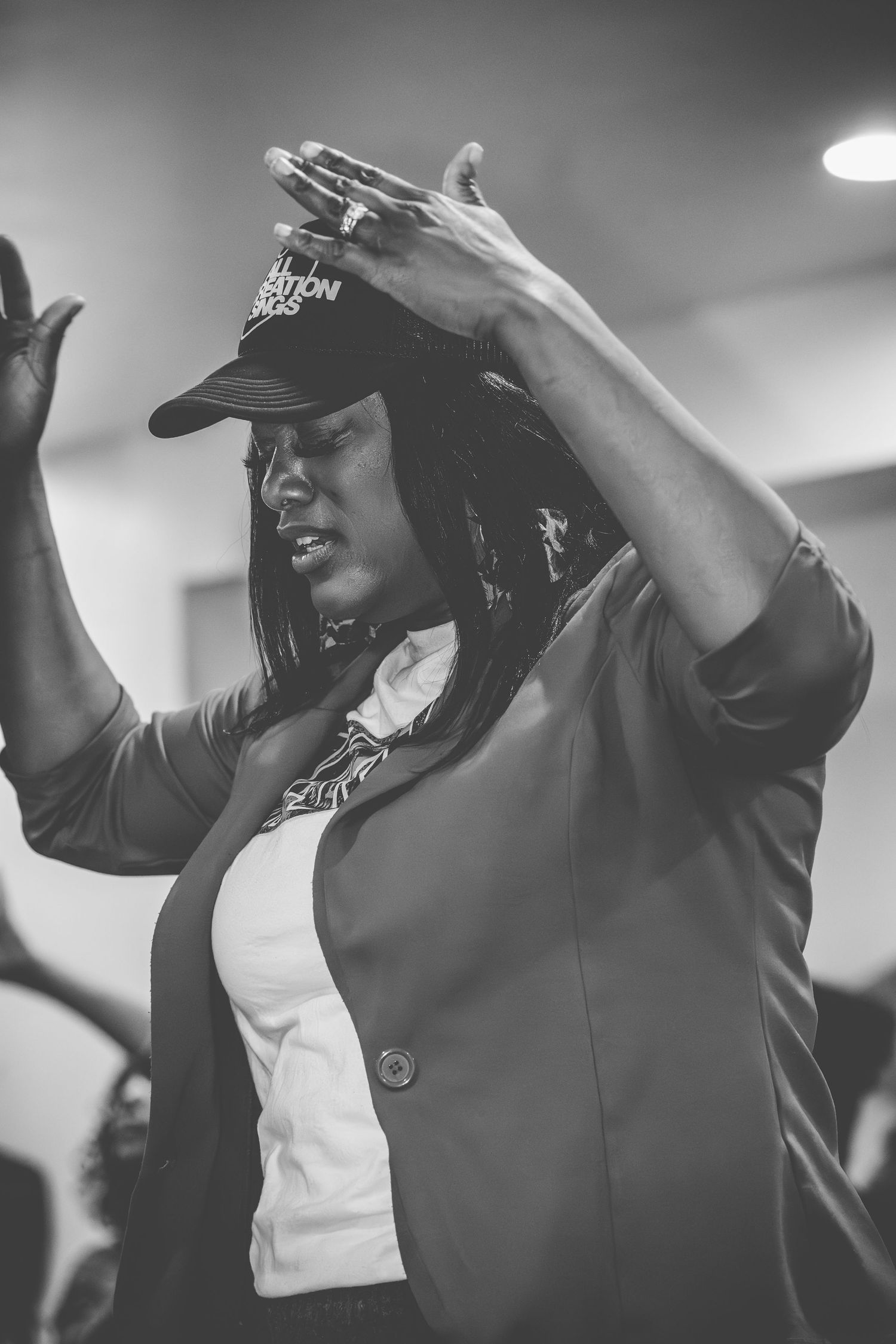 Black and white photo of people with raised arms dancing and celebrating in an indoor space.