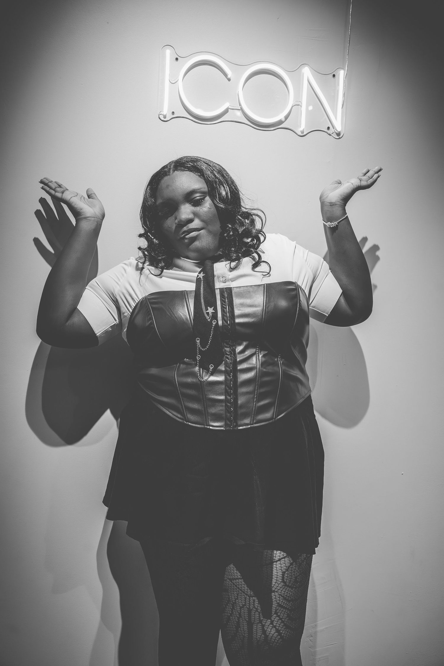Black and white photo series showing expressive poses against a light background with neon signage.