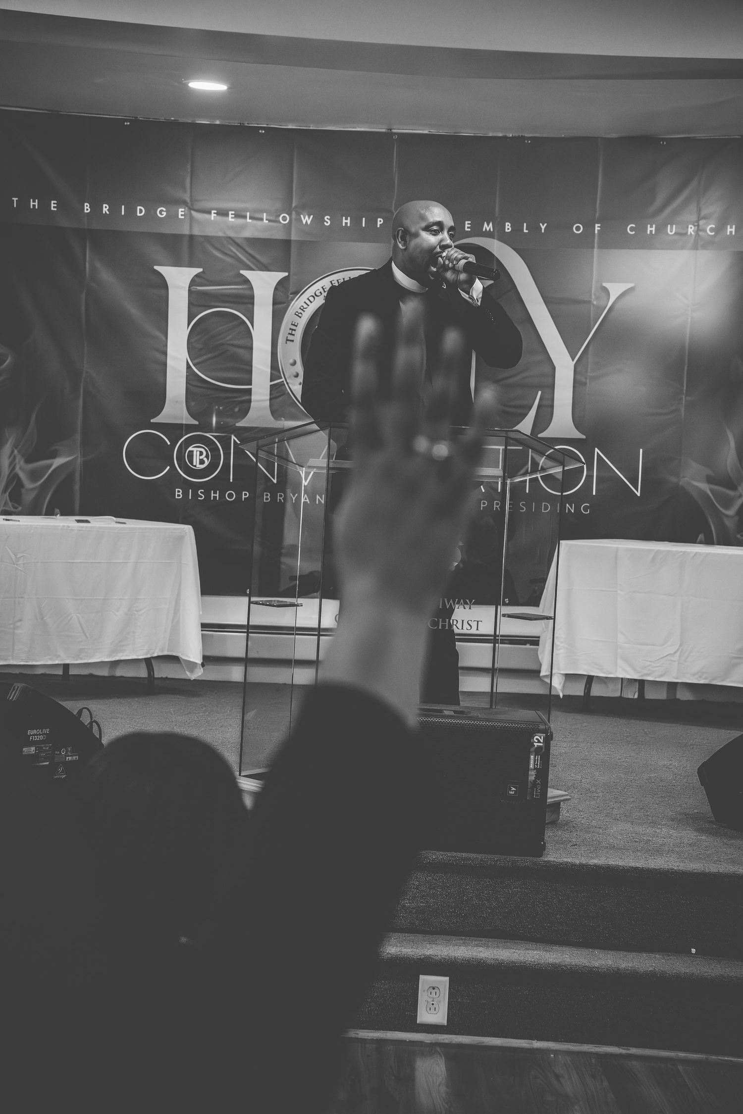 Black and white church stage setup with modern lighting and worship text displays.