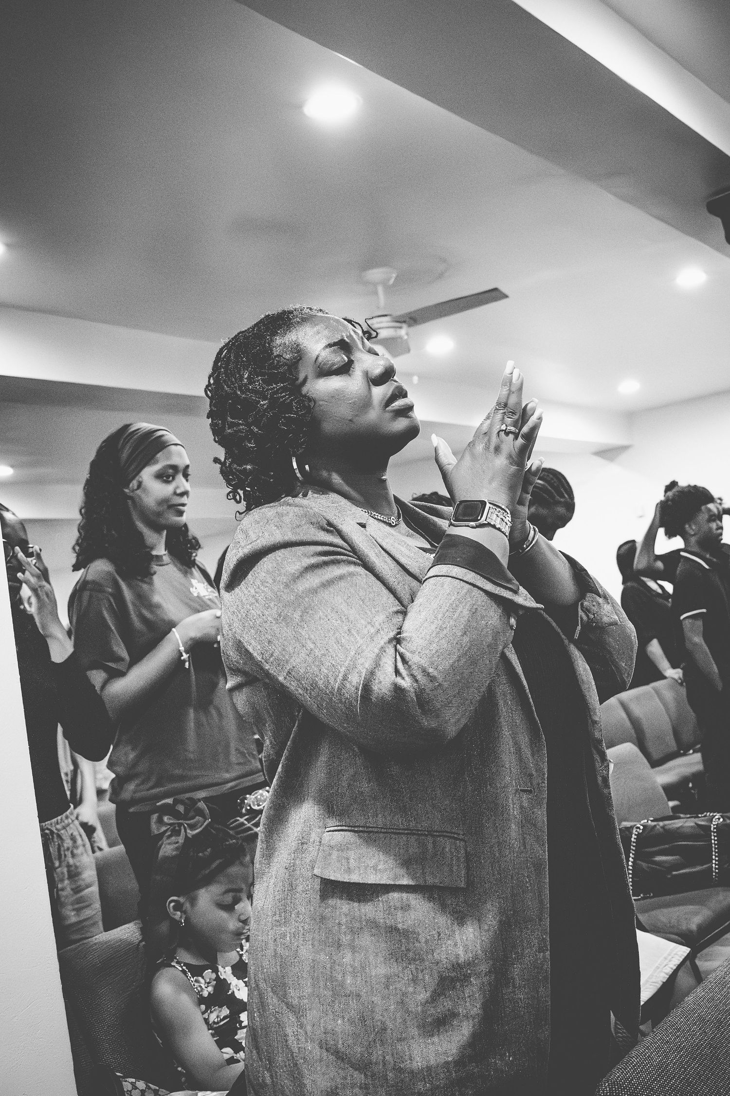 A sequence of black and white photos showing people singing passionately in what appears to be a church or worship setting.