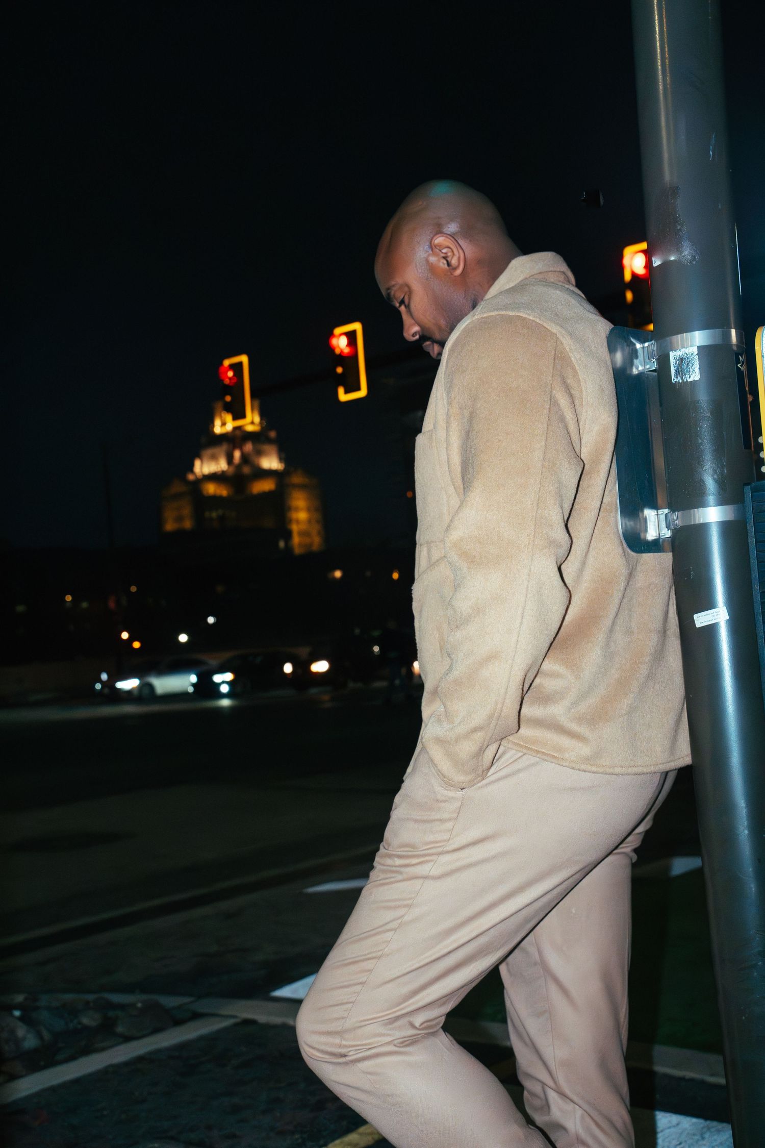 A person in a beige hoodie is shown in a sequence of nighttime photos near illuminated street poles.