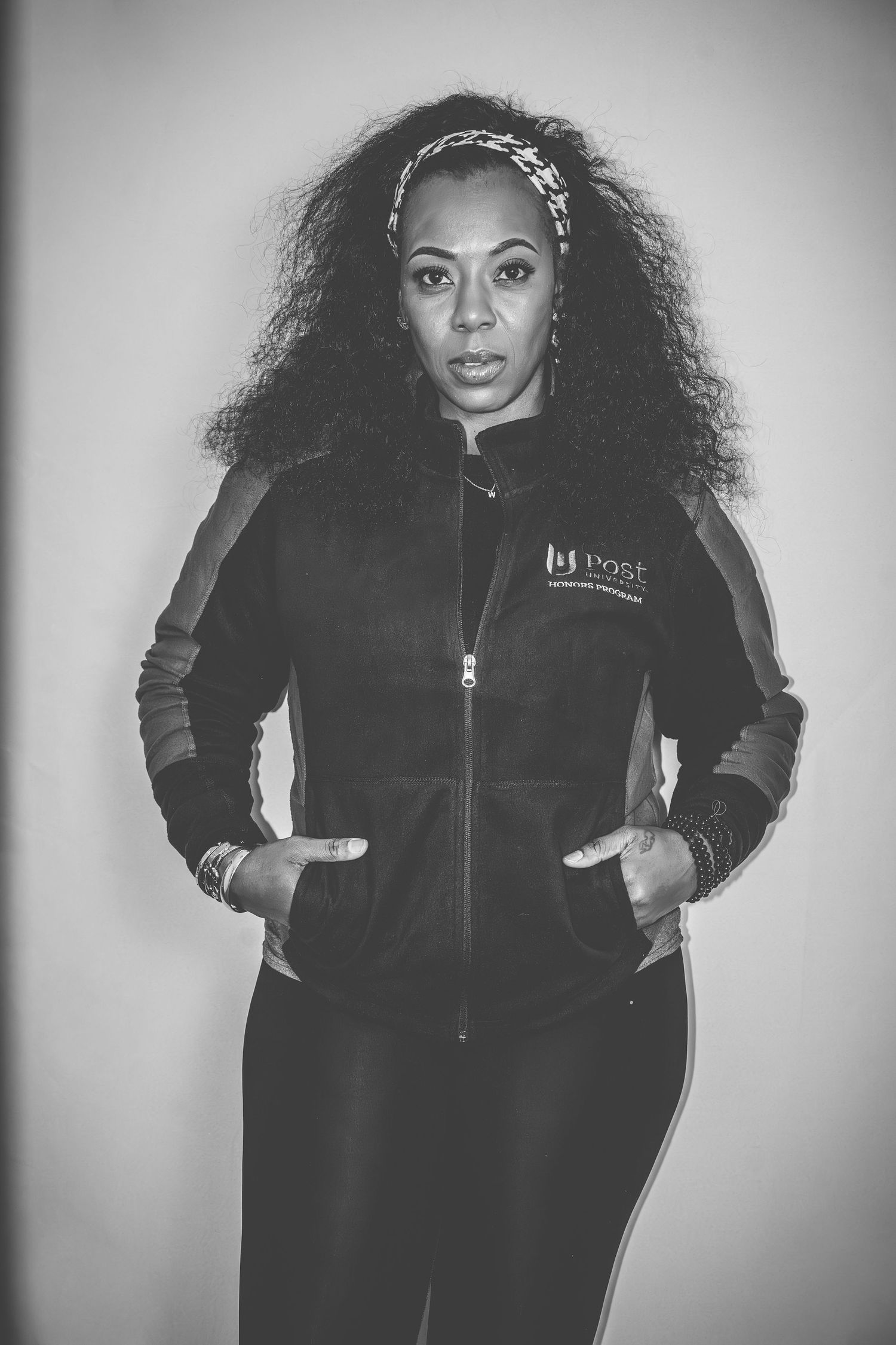 A black and white portrait showing a fleece jacket with company branding against a plain backdrop.