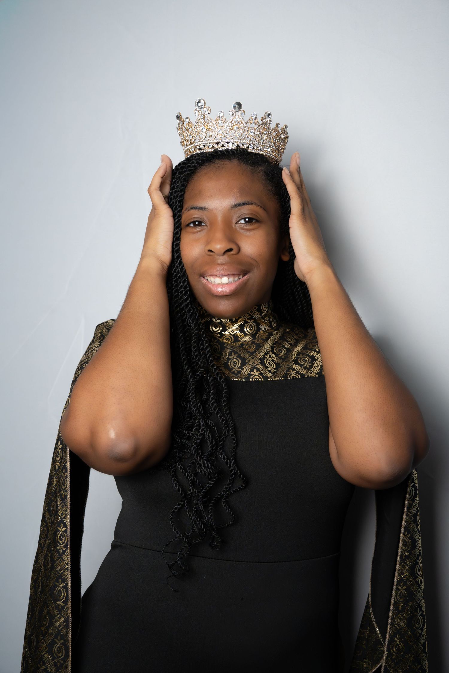 A sequence showing someone adjusting a decorative crown against a light gray background.