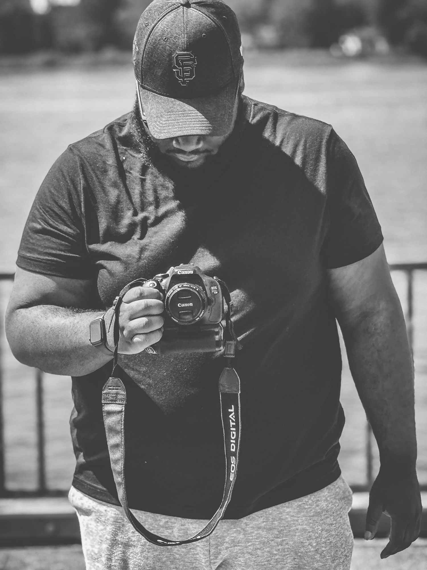 Black and white image of photographers with cameras working at an outdoor location.