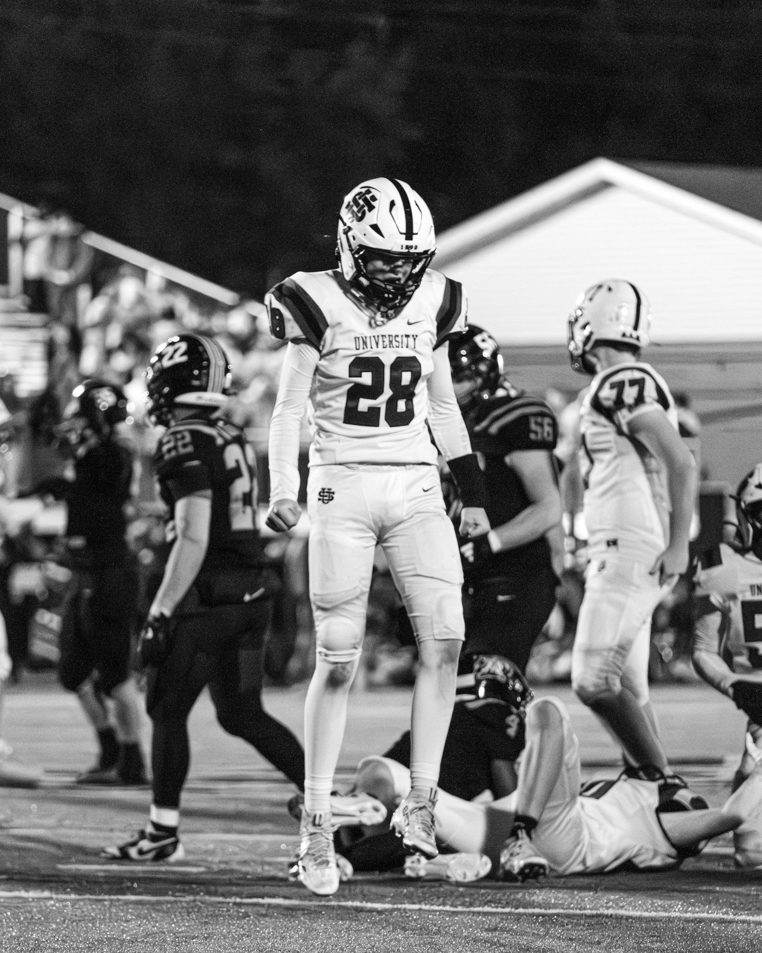 Football player number 28 in University uniform celebrates a play in black and white photo.