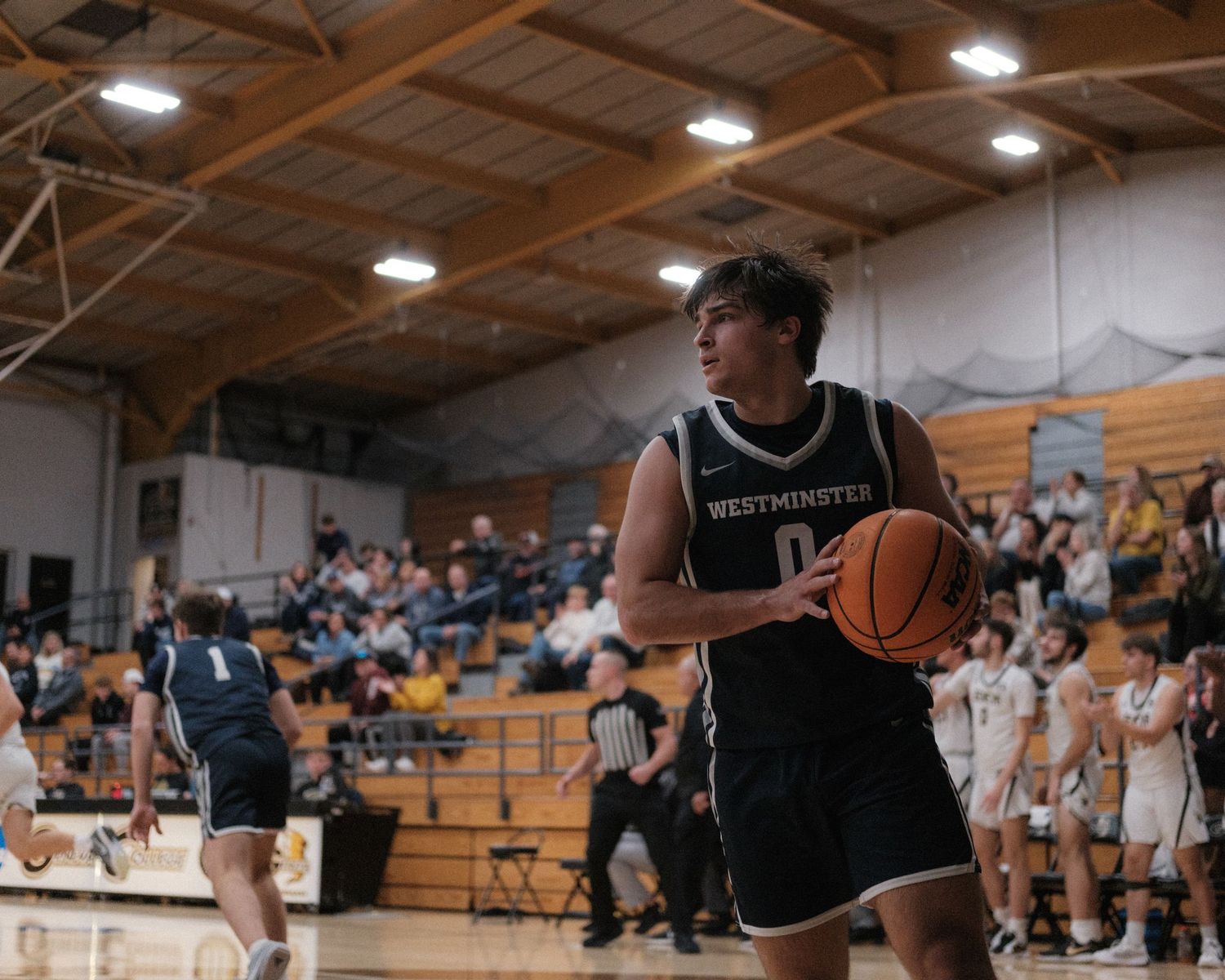 Westminster basketball player number 0 preparing to shoot during an indoor basketball game.