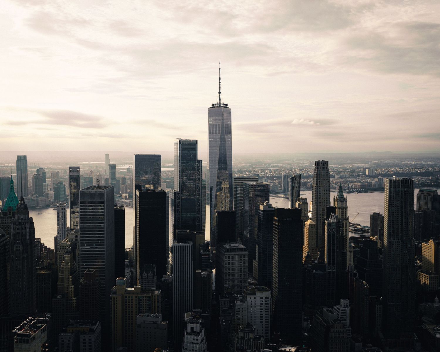 Aerial view of New York City skyline featuring One World Trade Center at dusk.