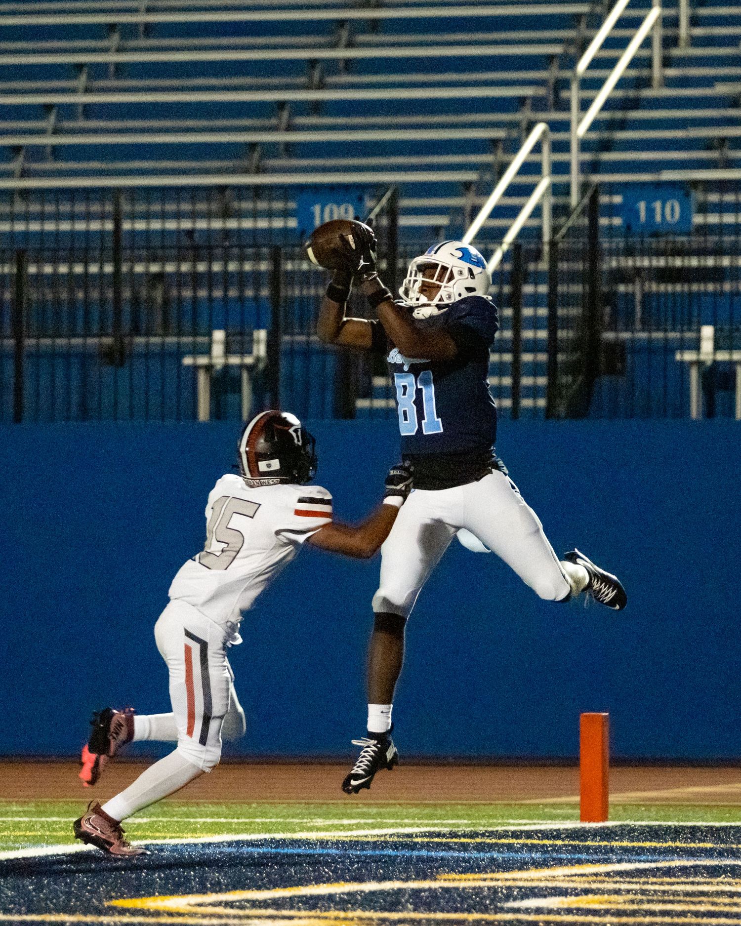 Benedictine football player number 81 leaps to catch a touchdown pass in the end zone.