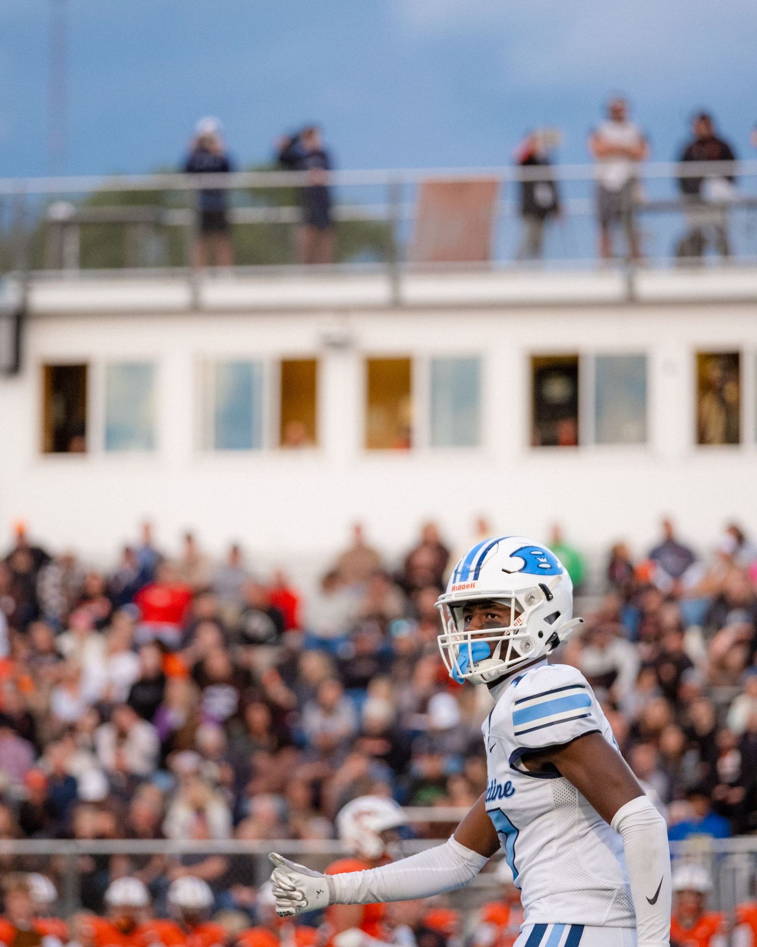 Benedictine football player stands on field with large crowd visible in the background.