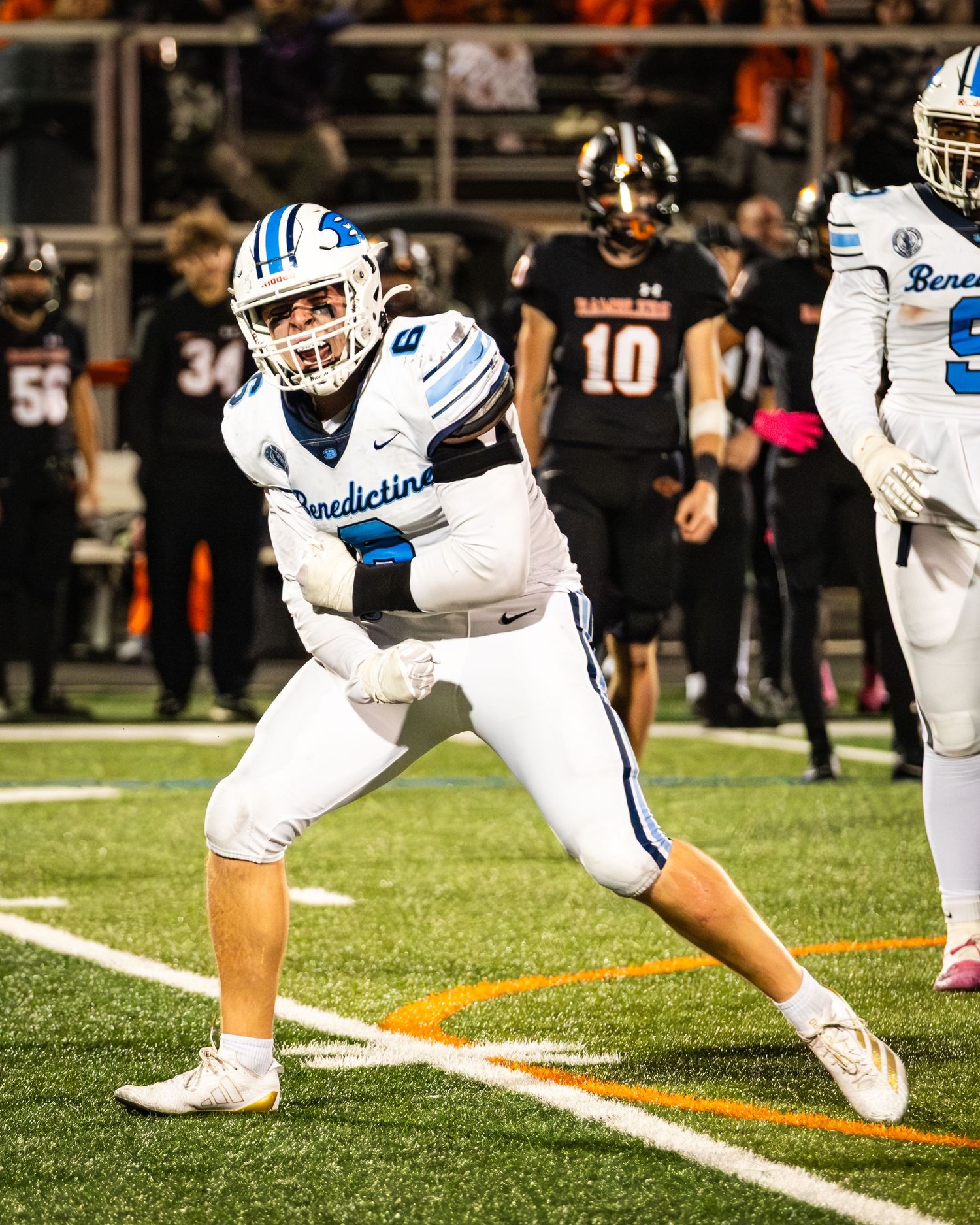 Benedictine football player #6 celebrates in white uniform on field.