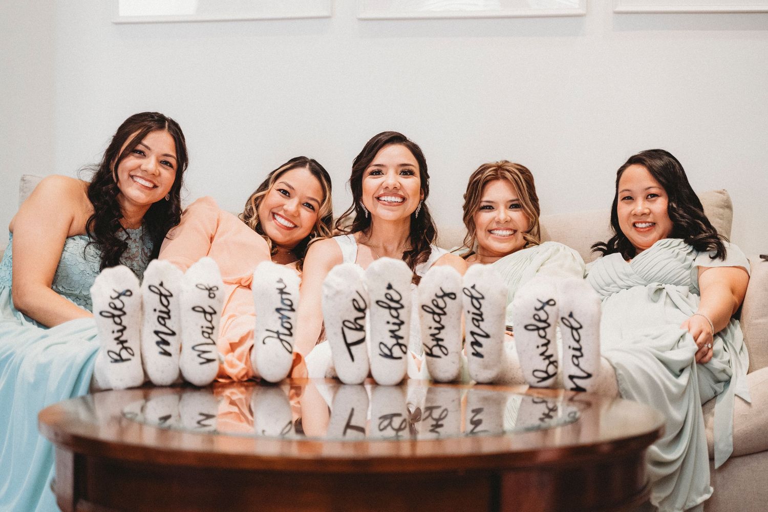 Bride with bridesmaids holding custom socks wedding party photo Waco TX Sudden Joy Visuals