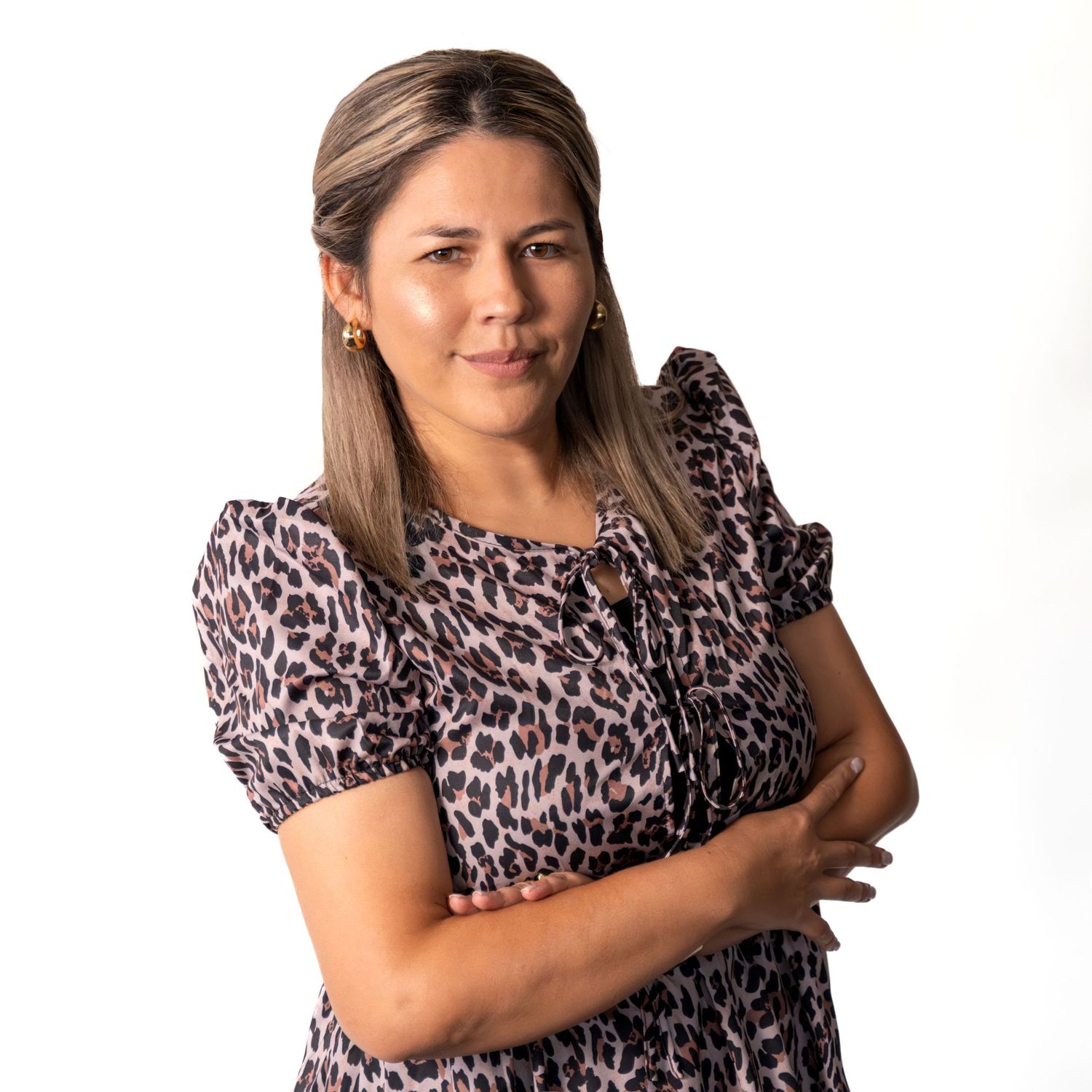 Professional headshot of person in leopard print top against white background.