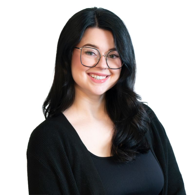 Professional headshot of person with glasses and black sweater against white background.
