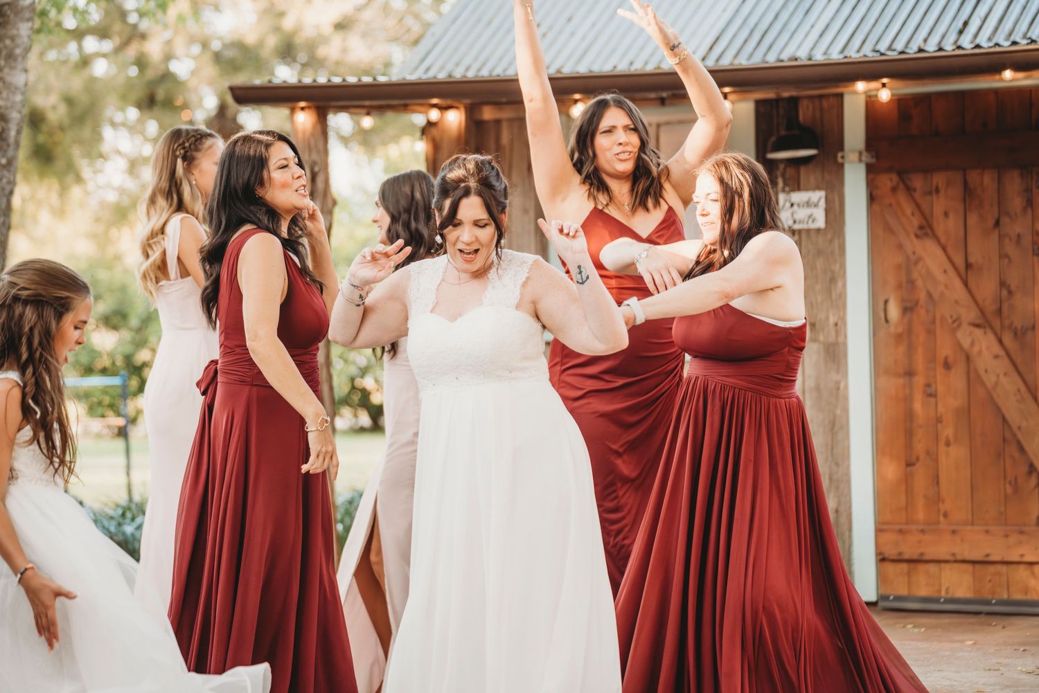 Bride celebrating with bridesmaids barn wedding reception Waco TX Sudden Joy Visuals