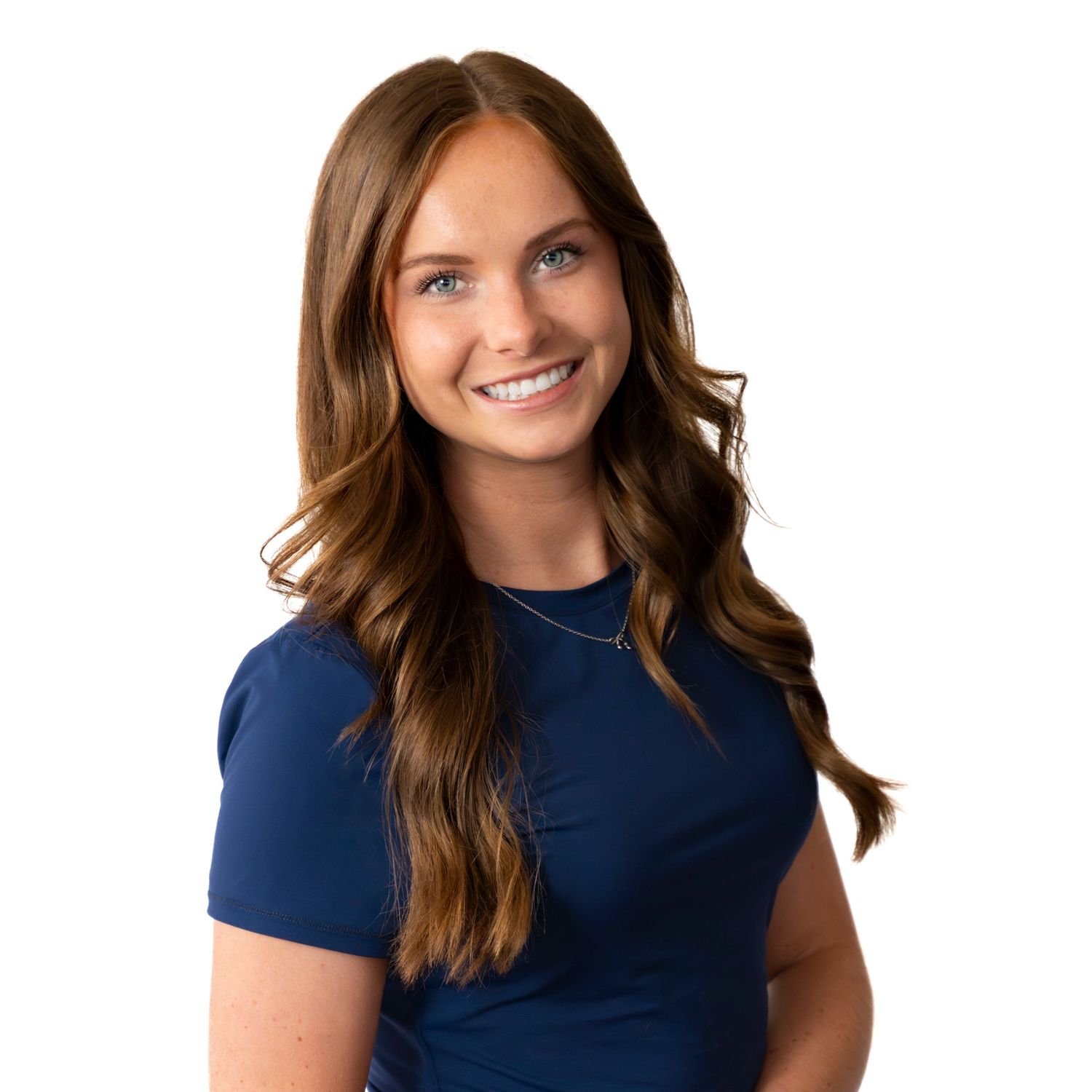 Professional headshot of person in navy blue top with wavy brown hair against white background.