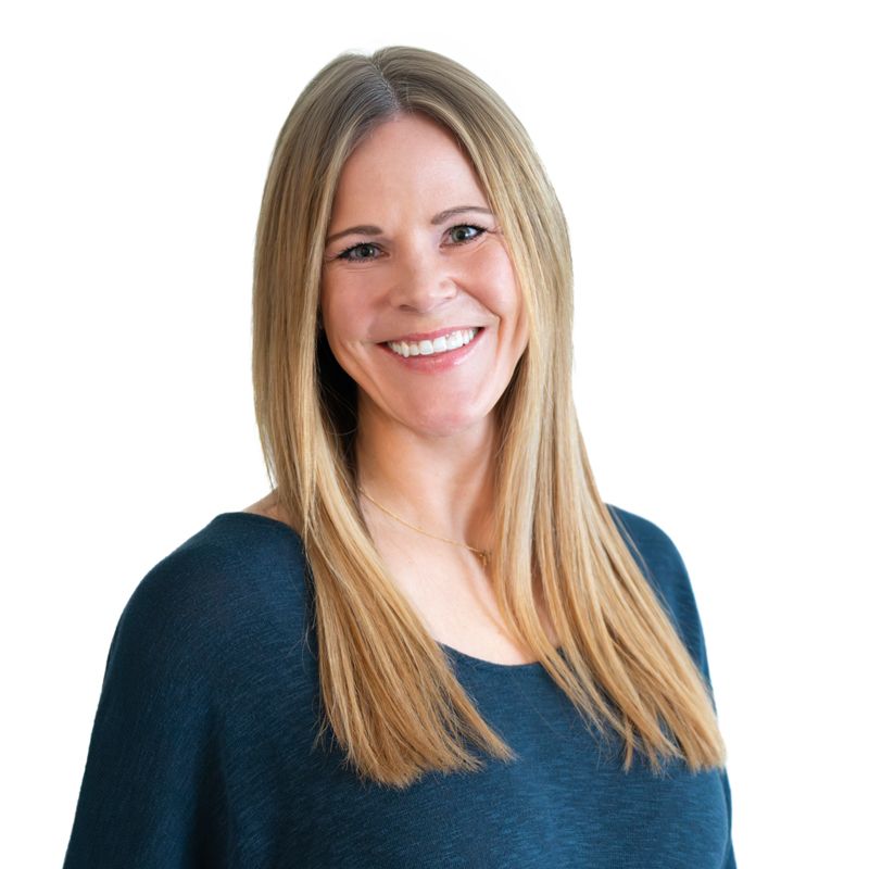 Professional headshot of person in navy blue top with long blonde hair against white background.