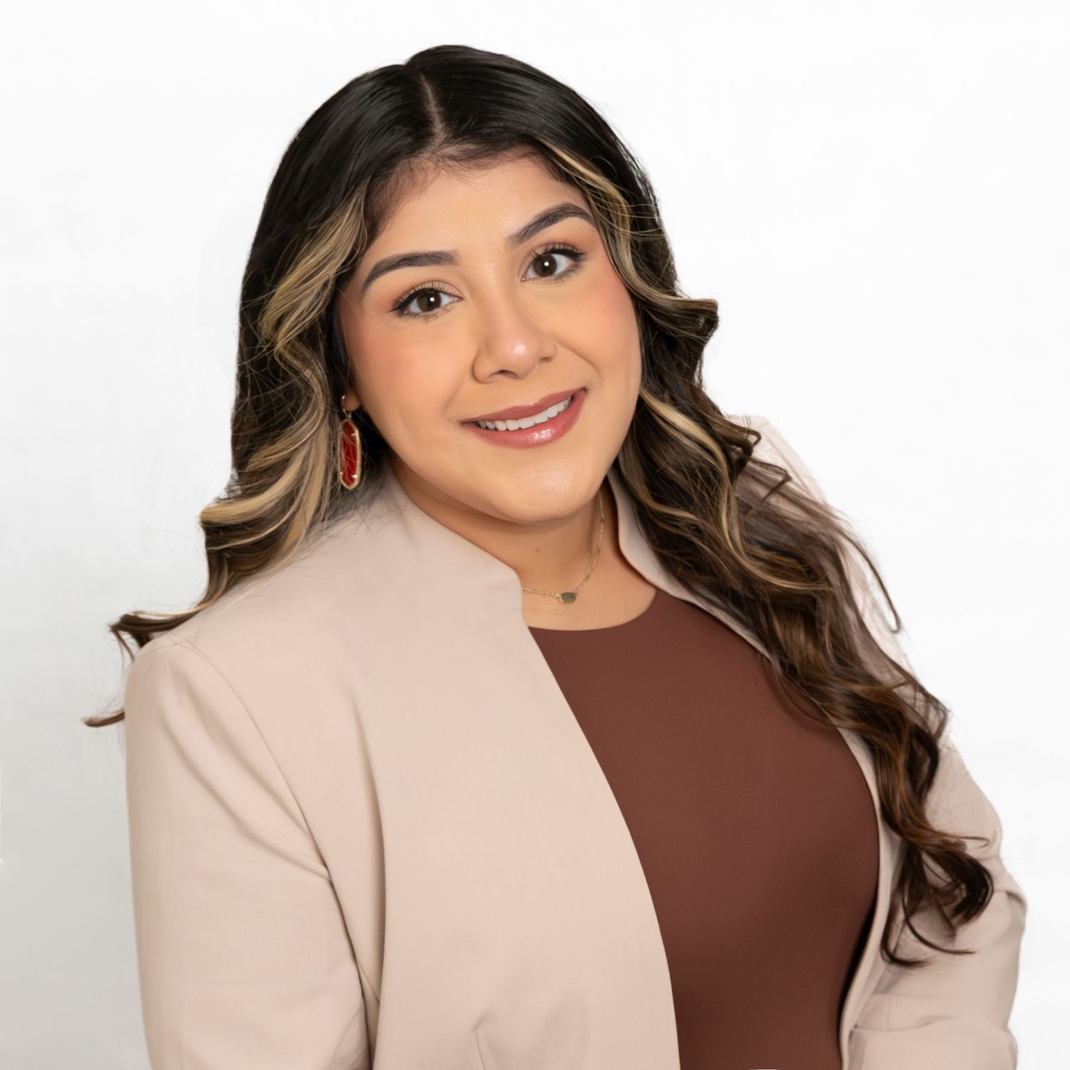 Professional headshot of person in beige blazer and brown top against white background.