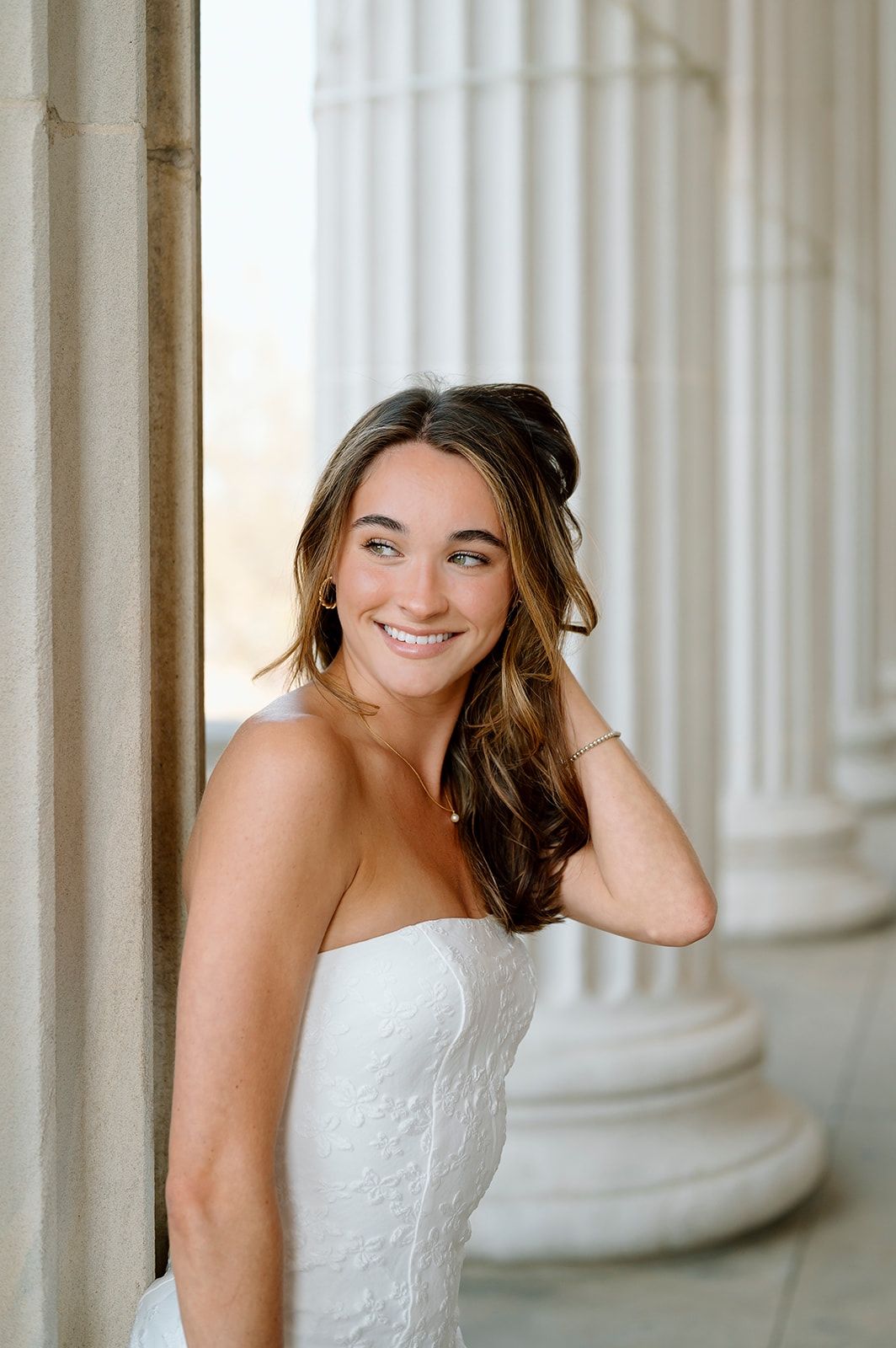 Elegant portraits between white classical columns in formal wear.