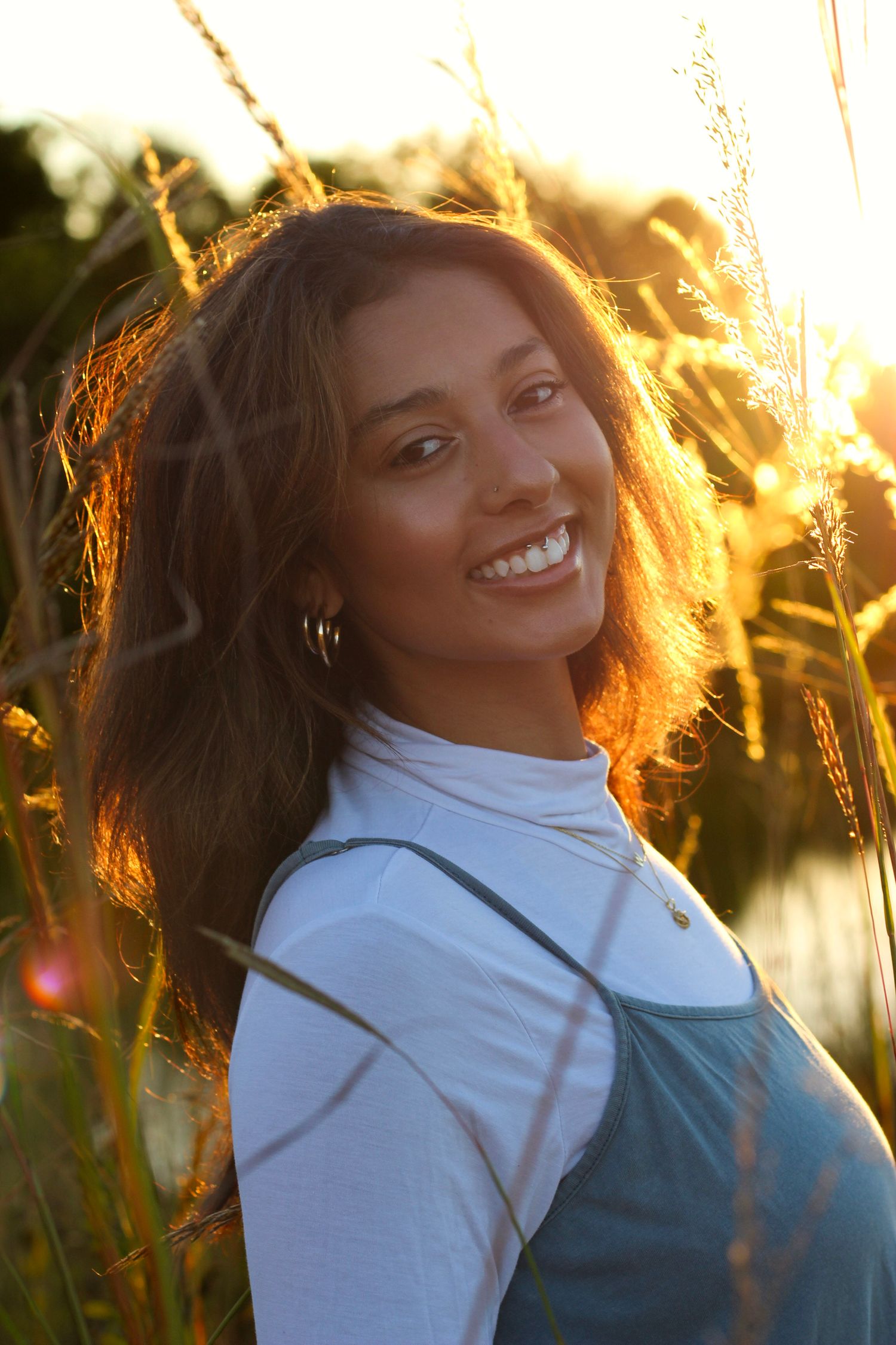 Natural laughter captured in golden hour light with water reflections in the background.