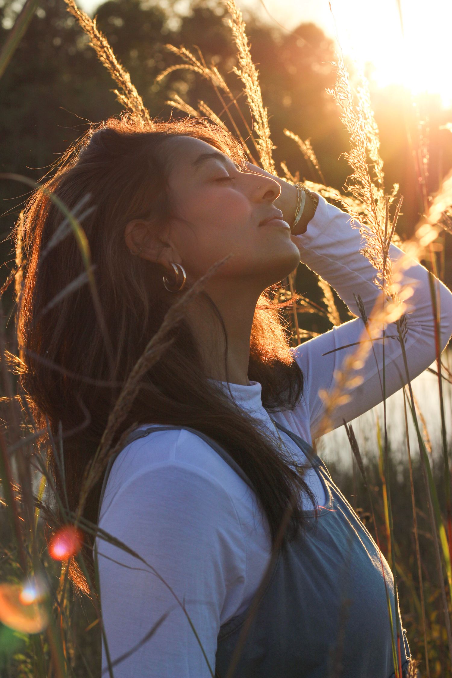 Peaceful moment captured in profile against golden sunlit reeds by the water.