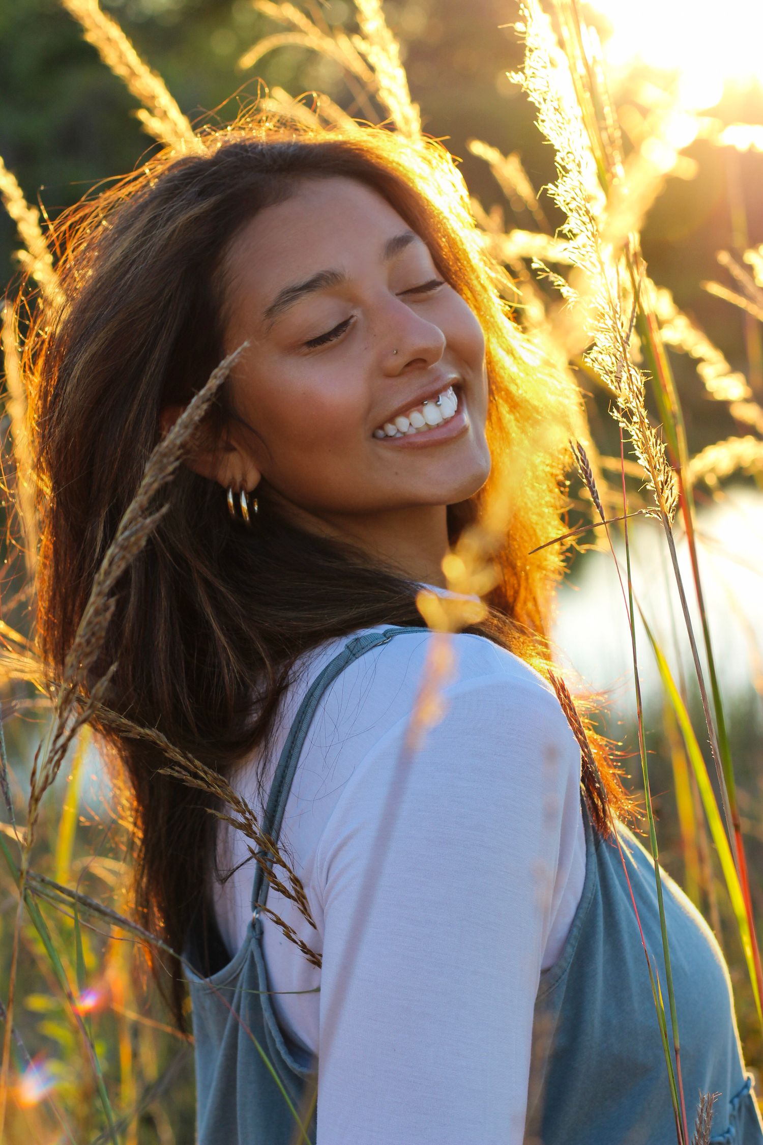 Warm sunset glow creates a dreamy atmosphere in this outdoor portrait among tall grass.