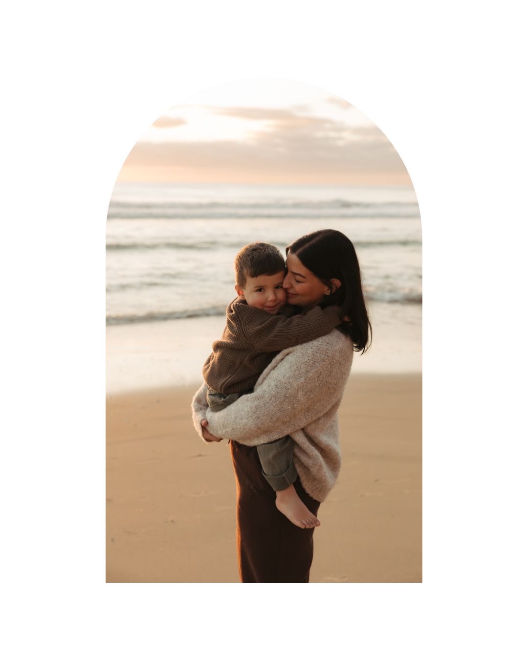 Intimate beach photoshoot silhouettes against warm sunset tones.