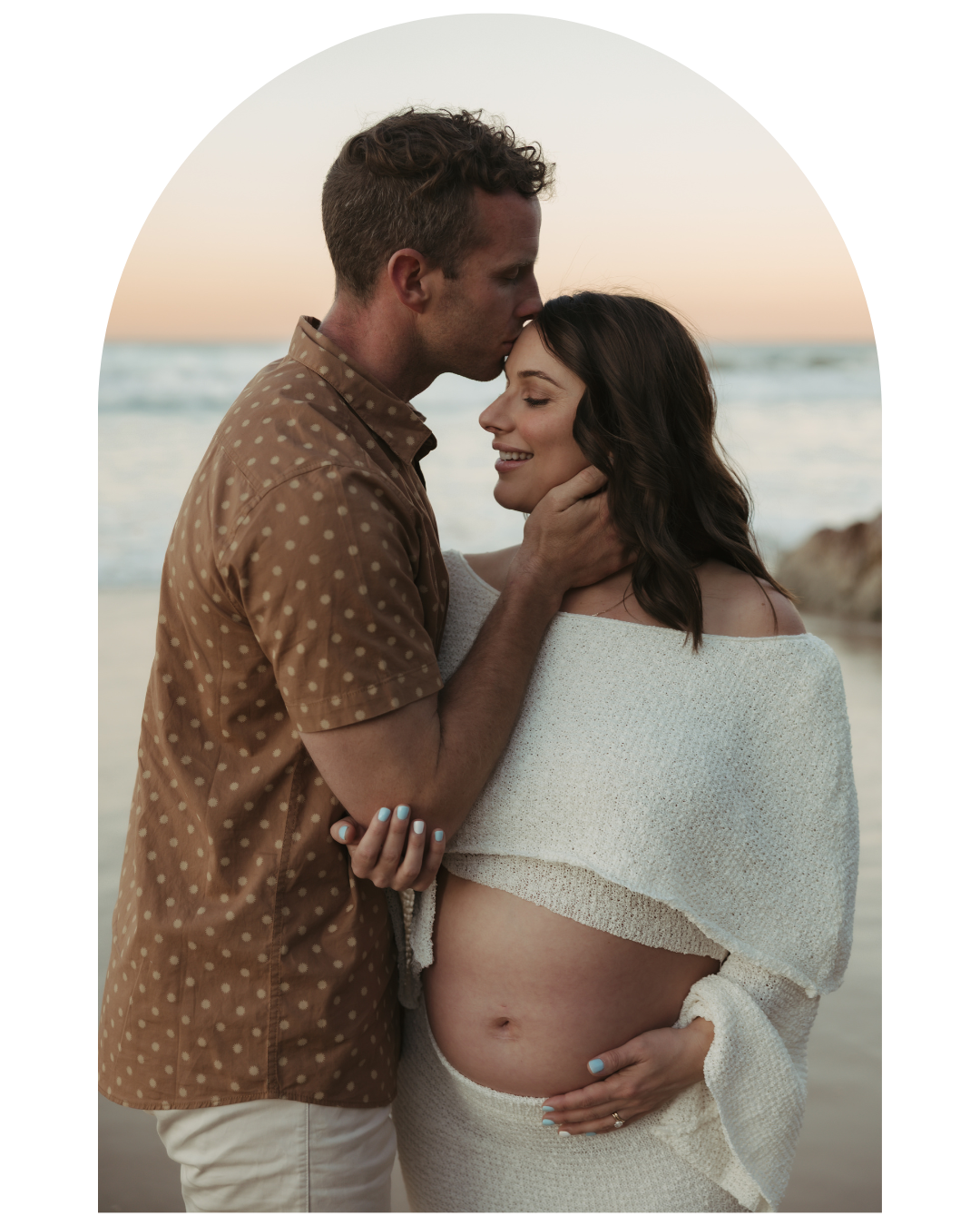 Intimate maternity photoshoot of couple at sunset on the beach.