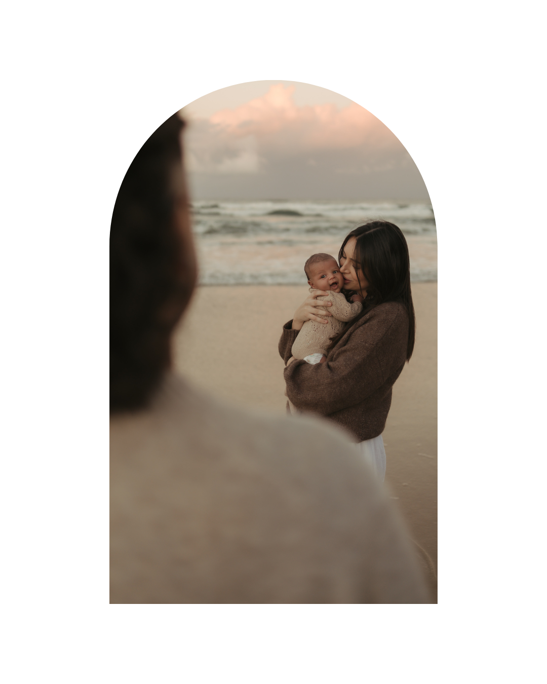 Romantic beach portraits with soft lighting and ocean backdrop.