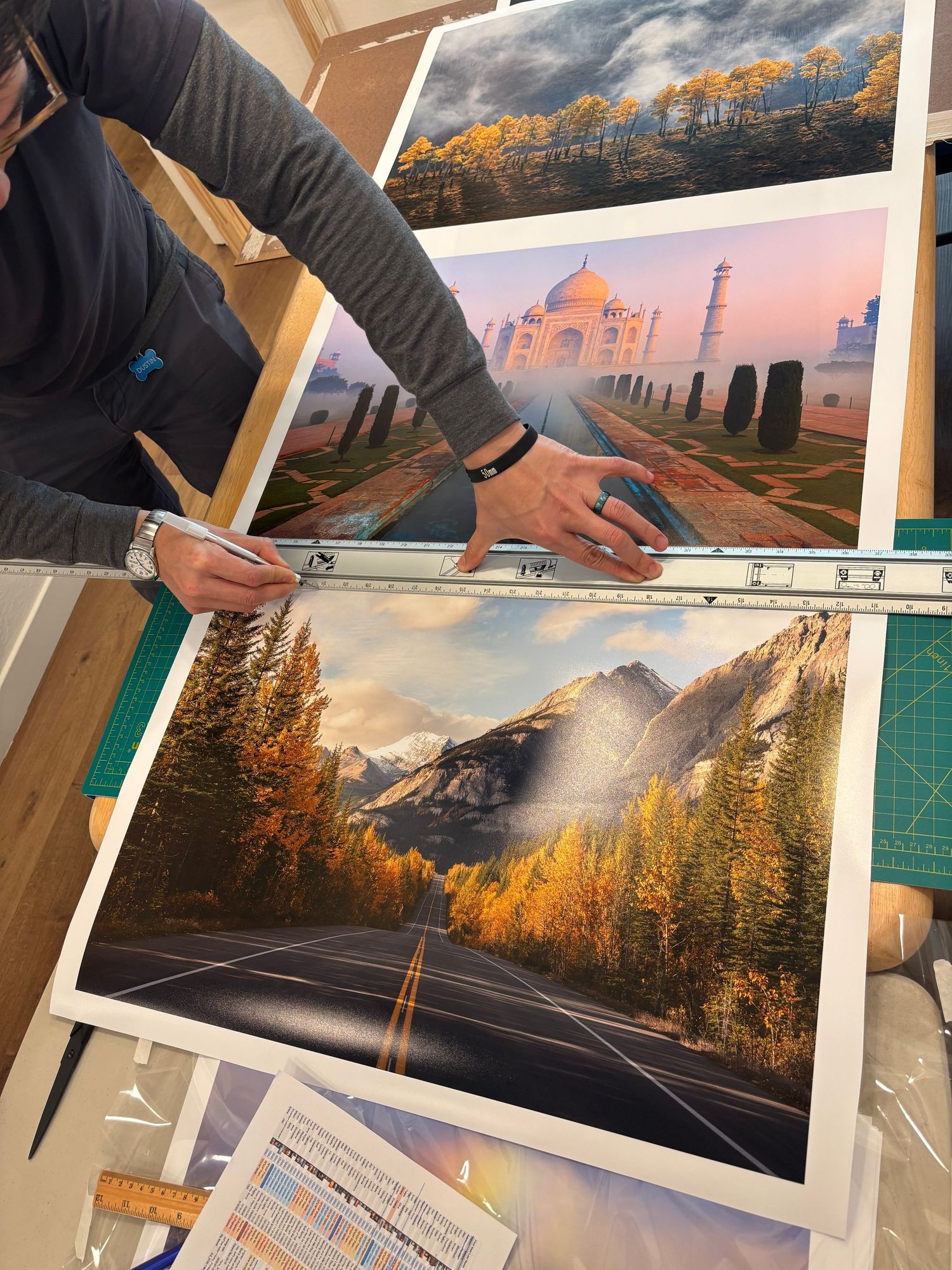 Multiple landscape photographs being arranged and prepared on a green cutting mat surface. Printed in Escaype Print Lab in Marin County, CA.