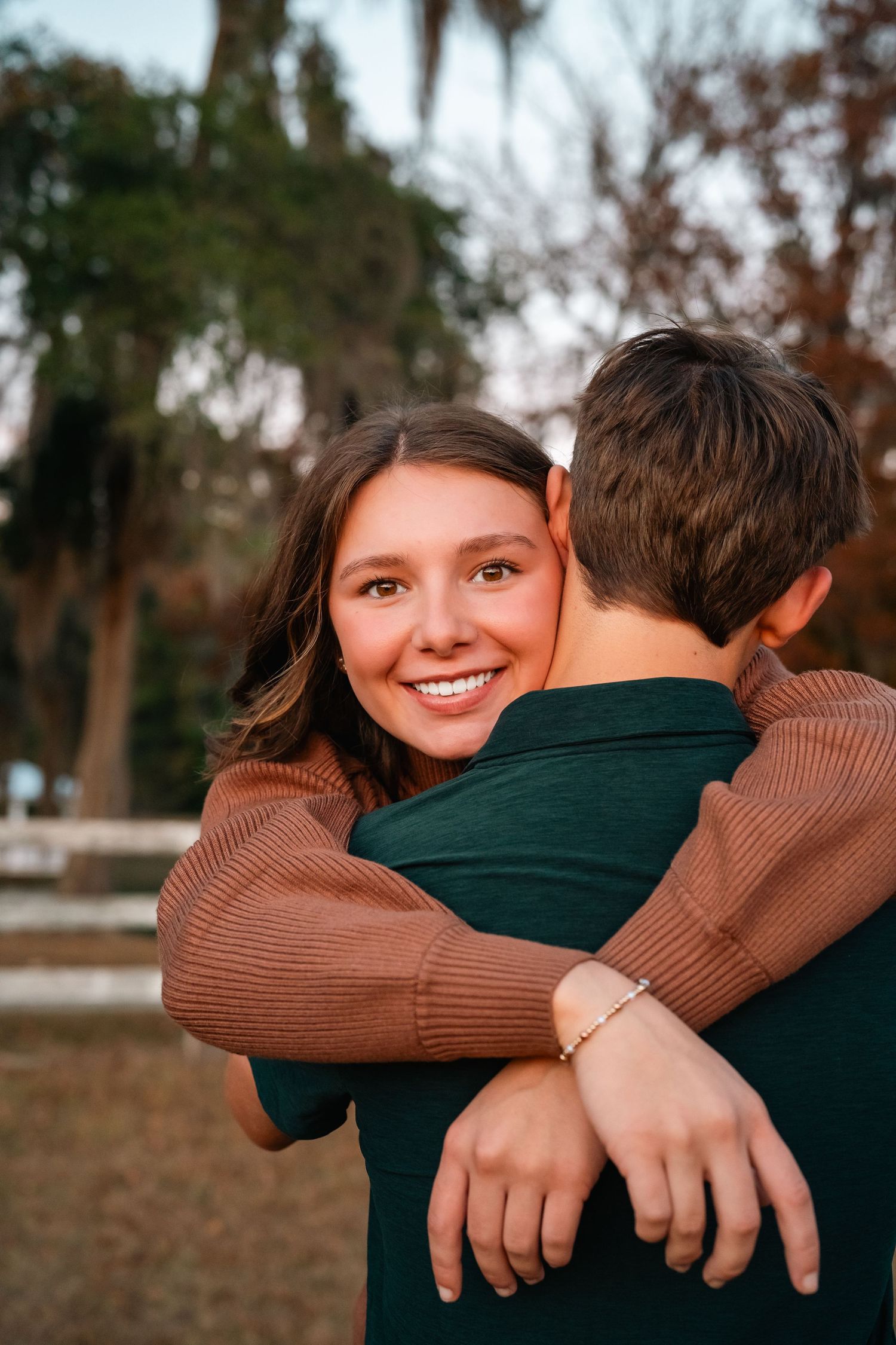 A series of four candid photos showing an intimate embrace between two people wearing brown and dark green sweaters.