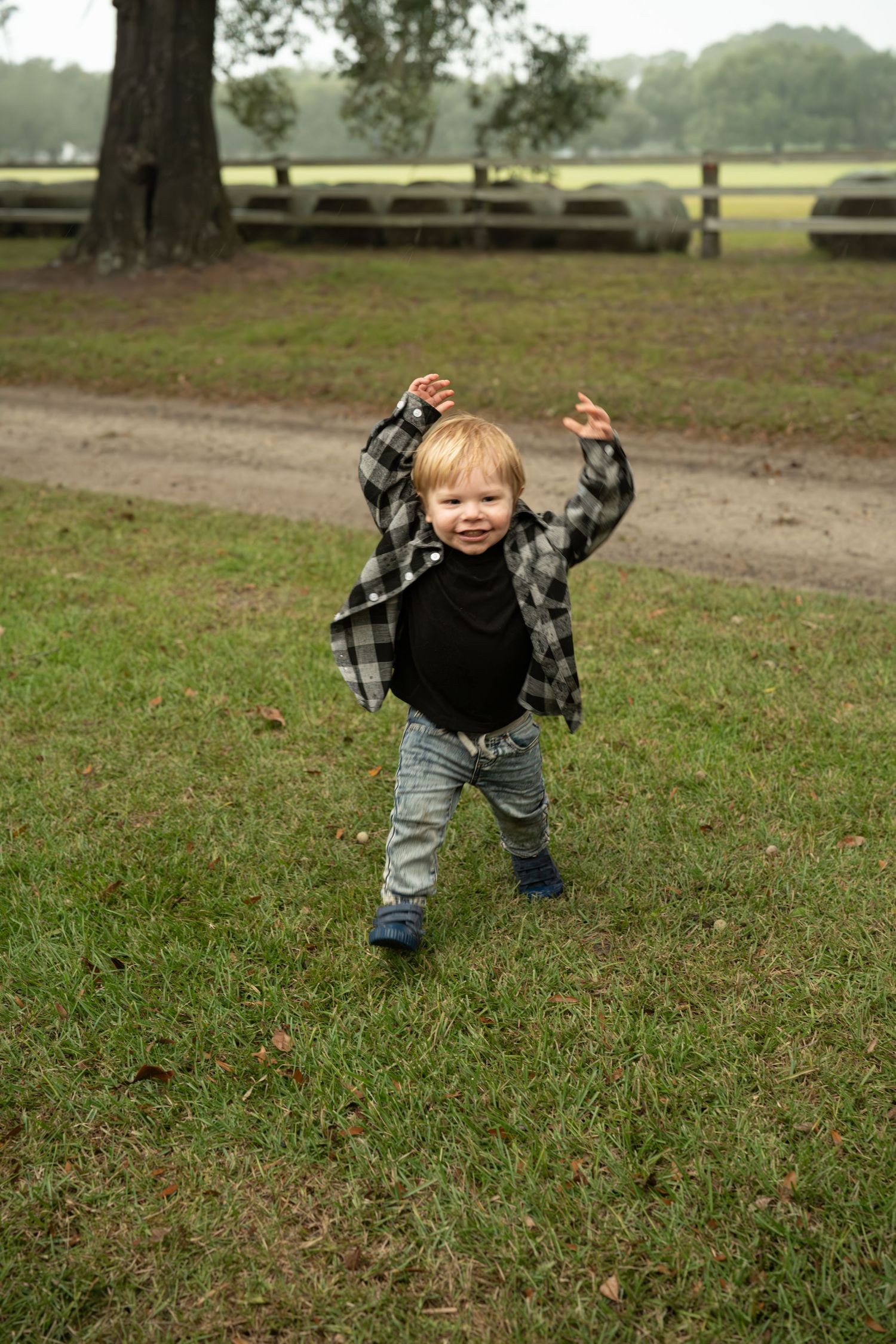 Sequence showing a toddler running and playing with arms raised on a grassy field.