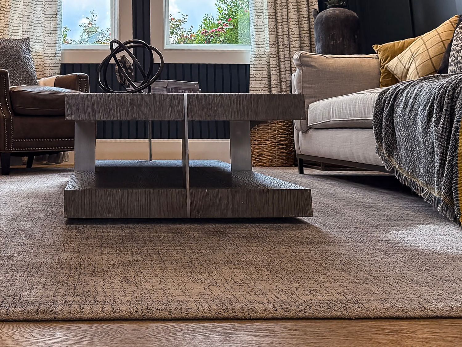Modern living room detail showing a contemporary coffee table on textured area rug.
