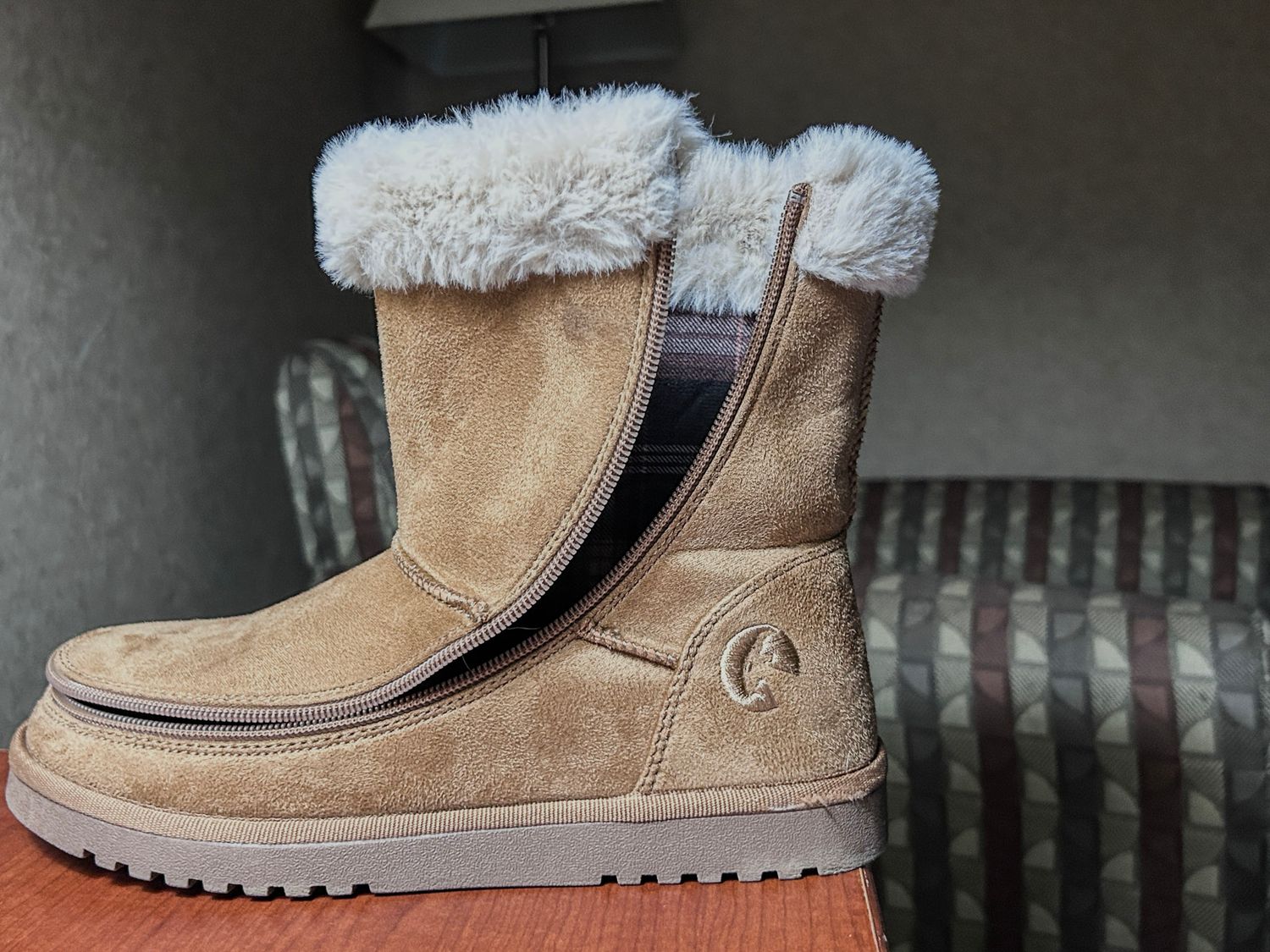 Side view of a casual winter boot with fur trim and rugged sole.