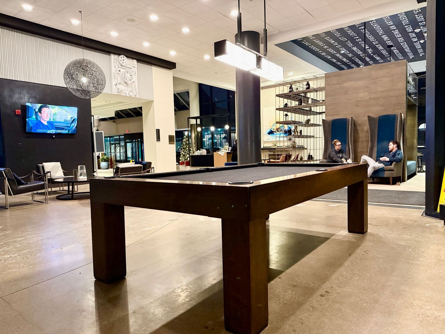 Modern bowling alley interior with sleek lanes, dark wood accents, and ambient lighting creates an upscale entertainment atmosphere.