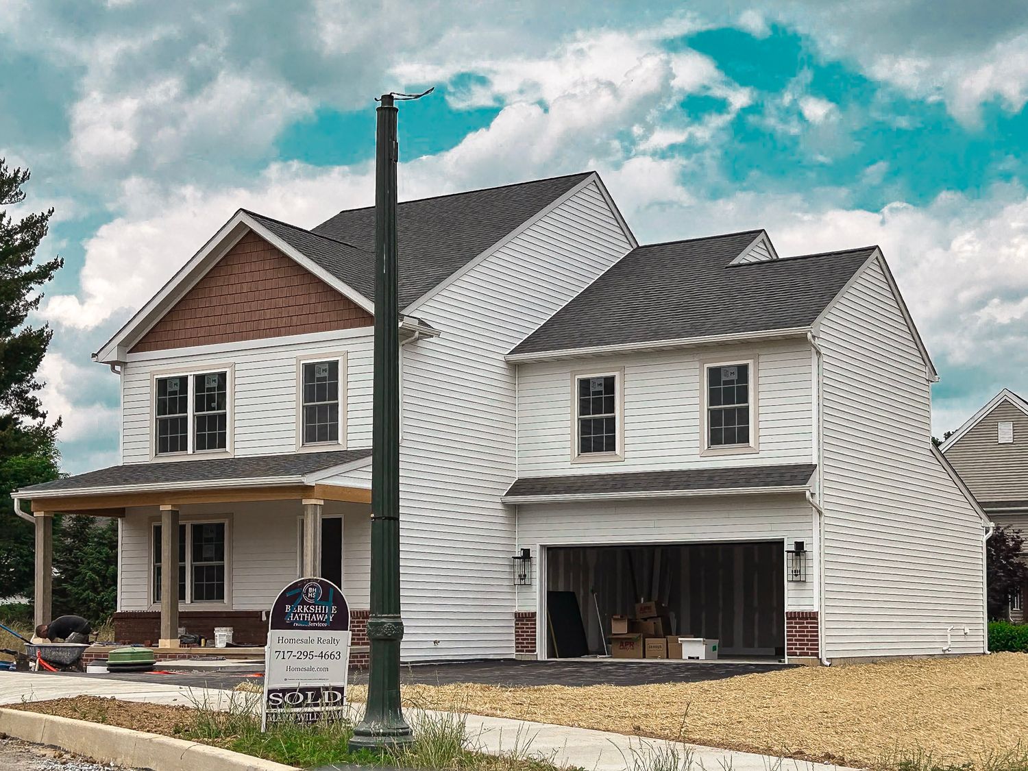 Row of newly constructed white residential homes with gray roofs and varied architectural styles.